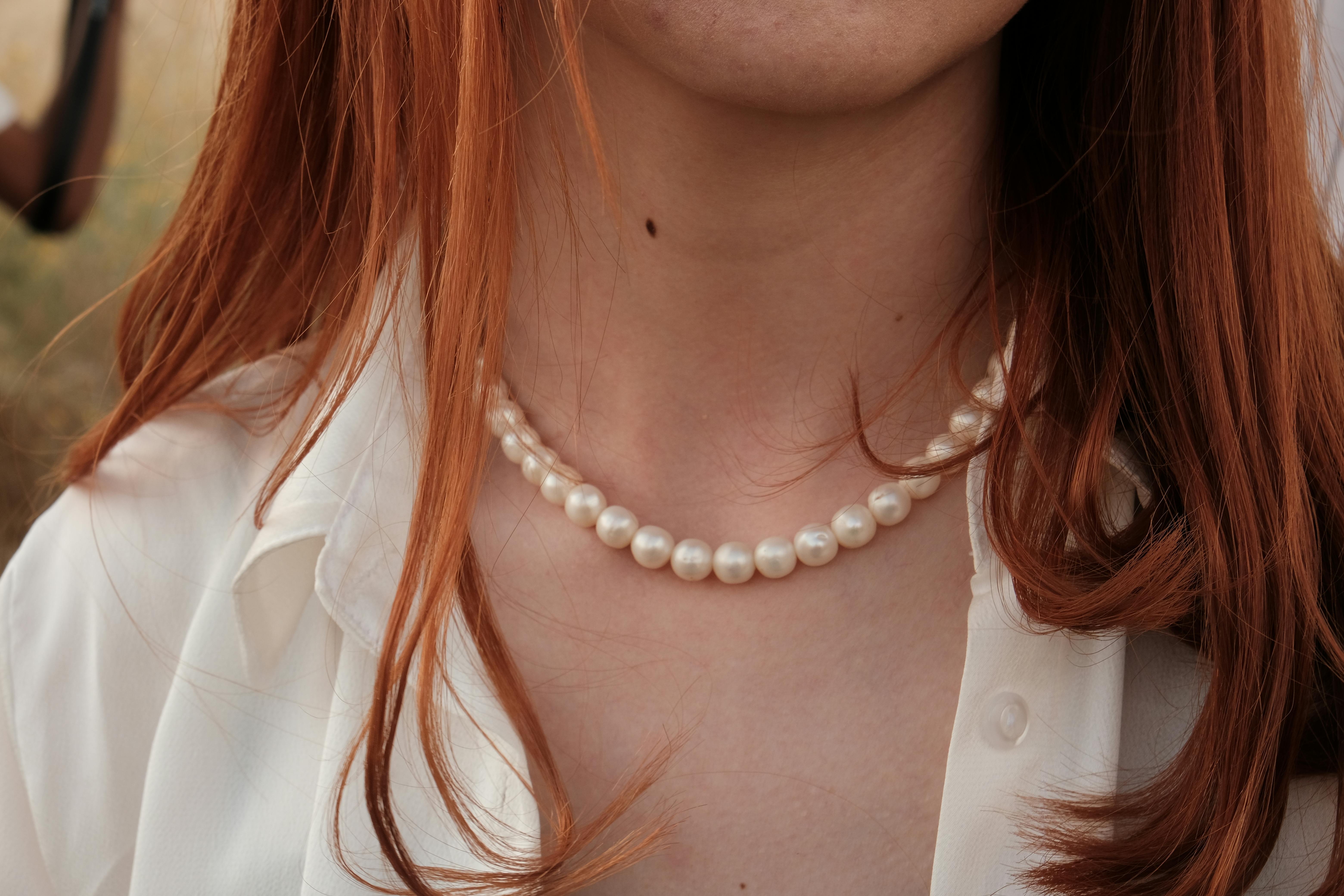 A woman wearing a pearl necklace | Source: Pexels