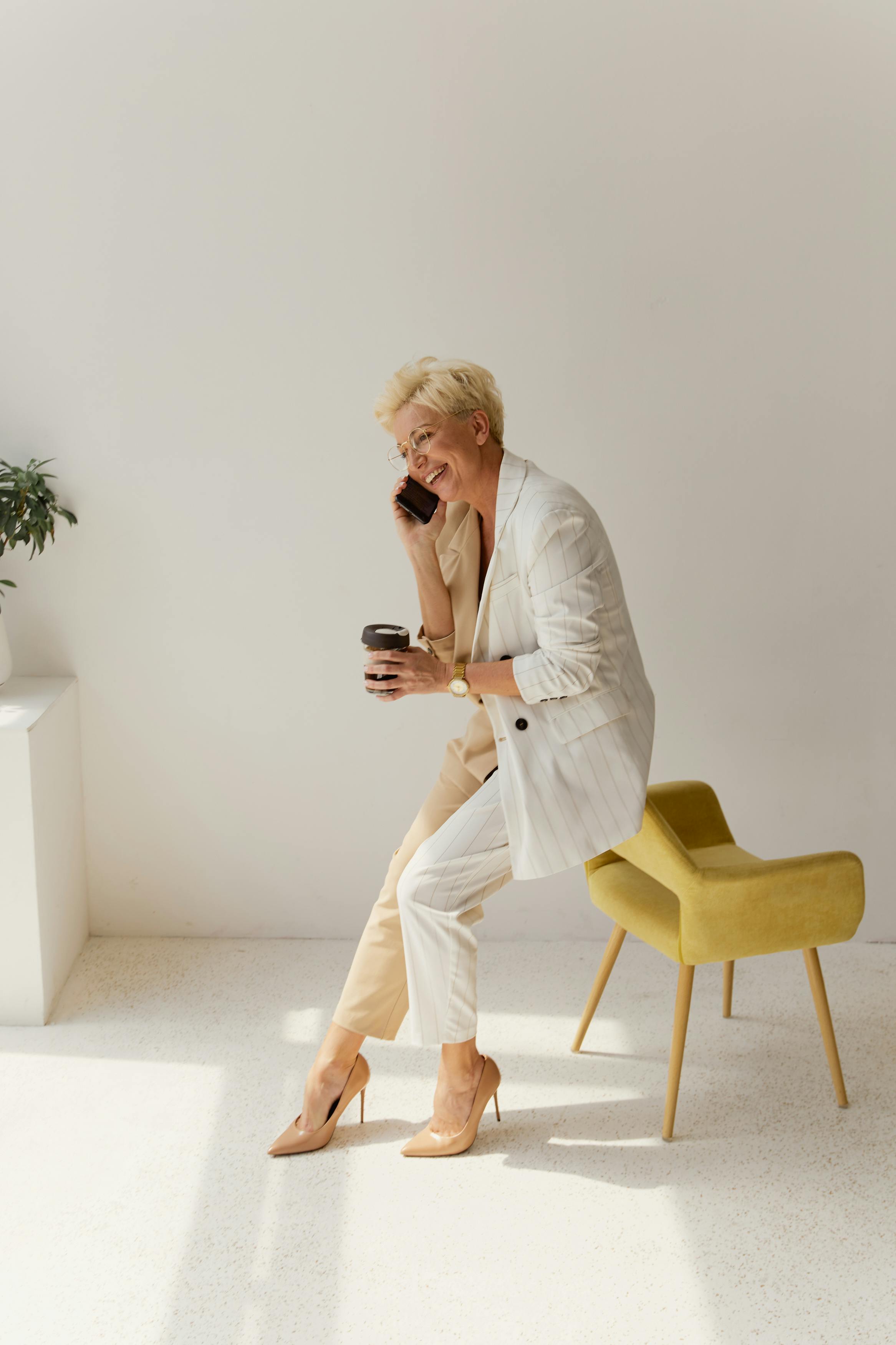 A laughing woman with a cup of coffee in her hand | Source: Pexels