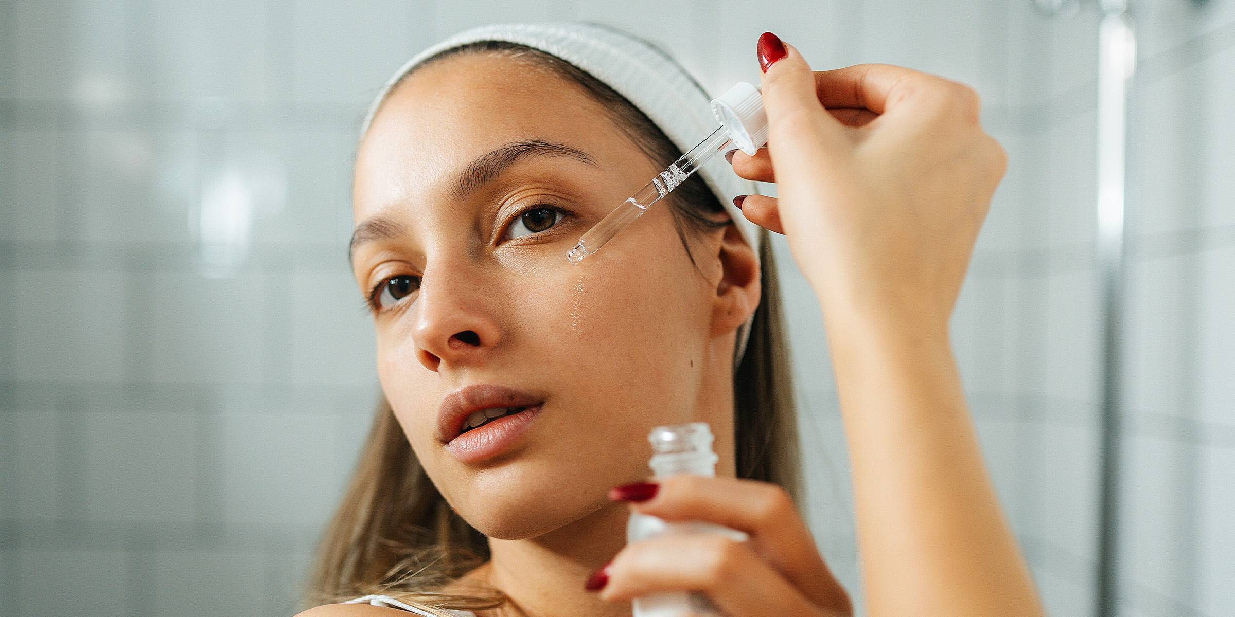 A woman applying serum to her face | Source: Getty Images