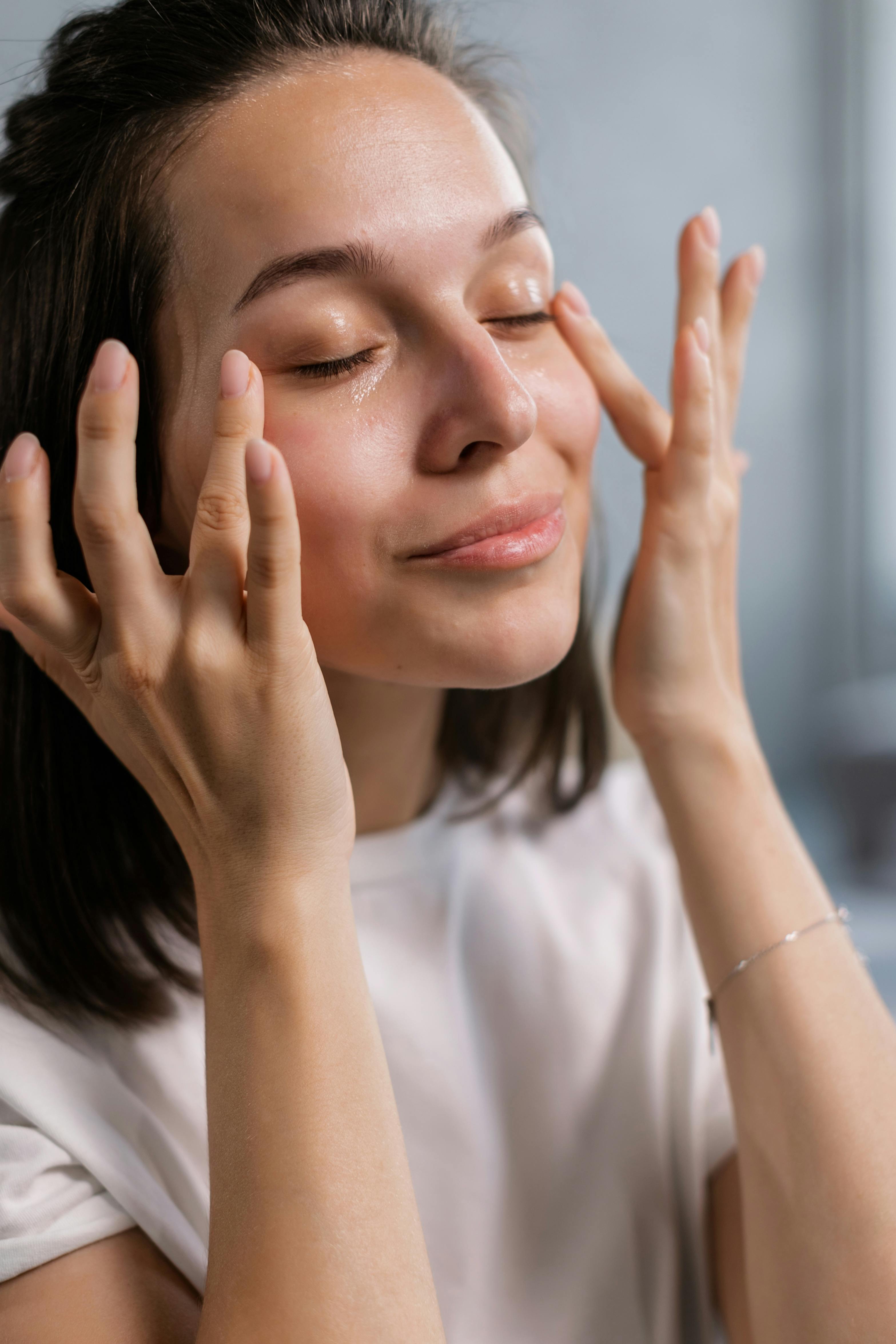A woman in white shirt patting the sides of her eyes | Source: Pexels