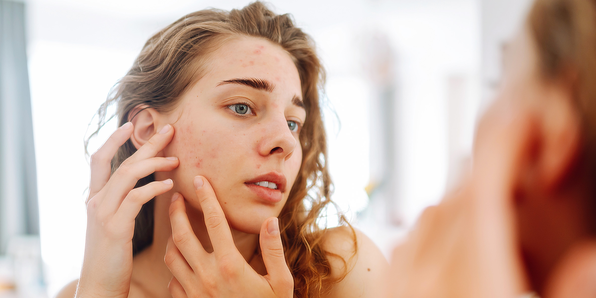 A woman inspecting her face in the mirro | Source: Getty Images