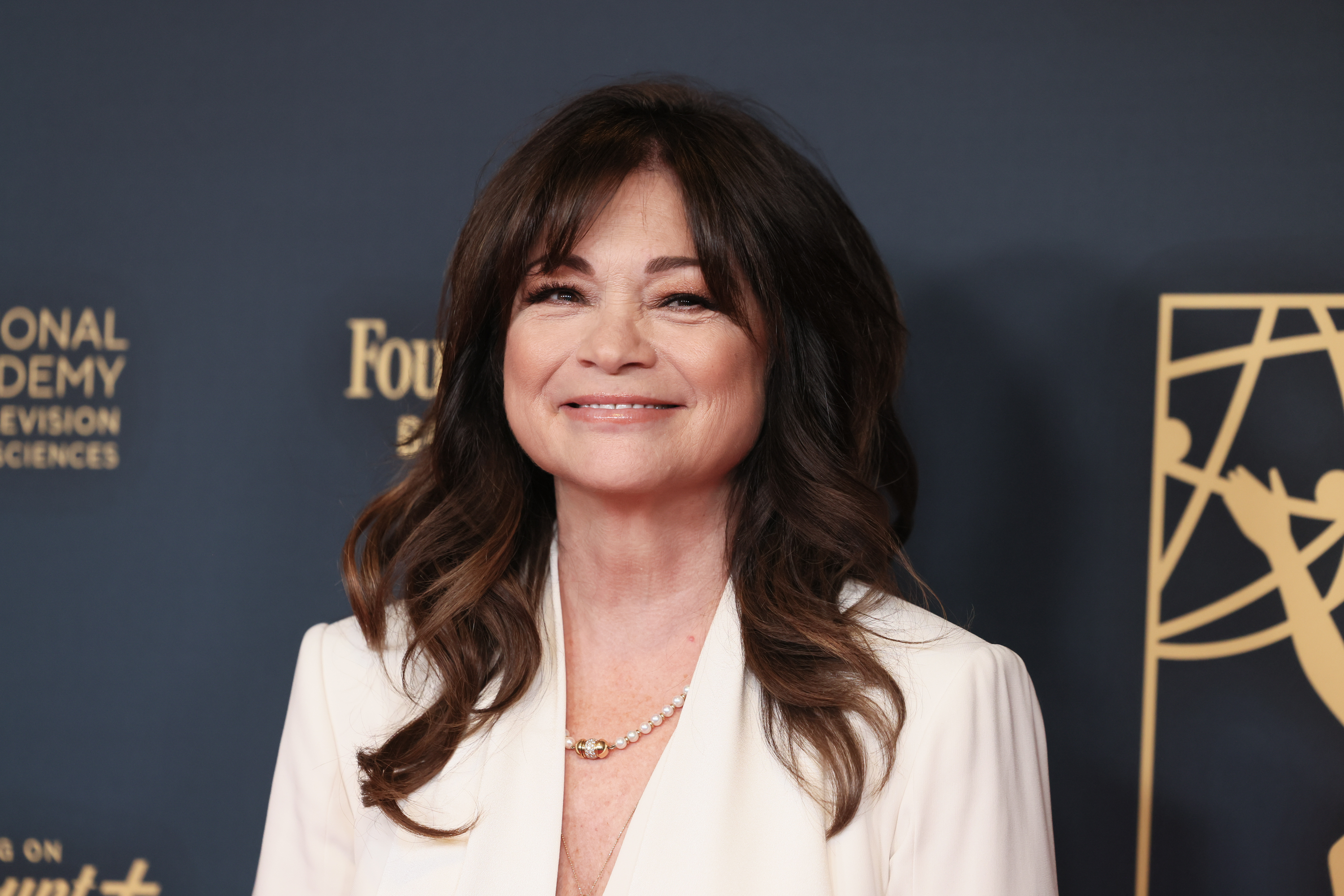 Valerie Bertinelli attends the 51st Annual Daytime Emmy Awards at The Westin Bonaventure Hotel & Suites in Los Angeles. She looks lovely in her brunette hair, now parted in the middle, wearing a warm smile as she poses for photos.