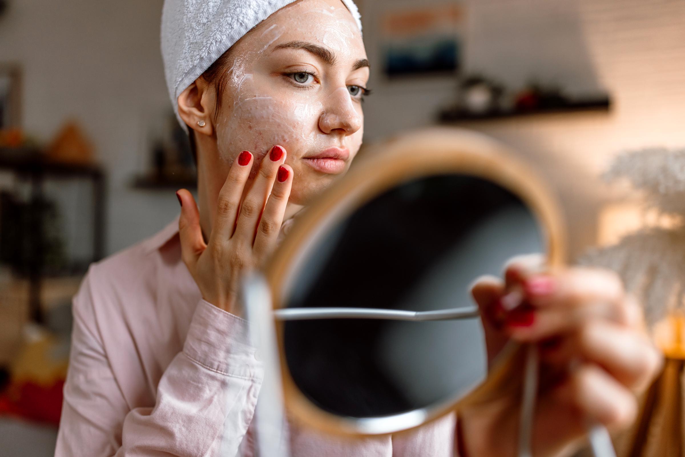 A woman applying a cream to her face | Source: Getty Images