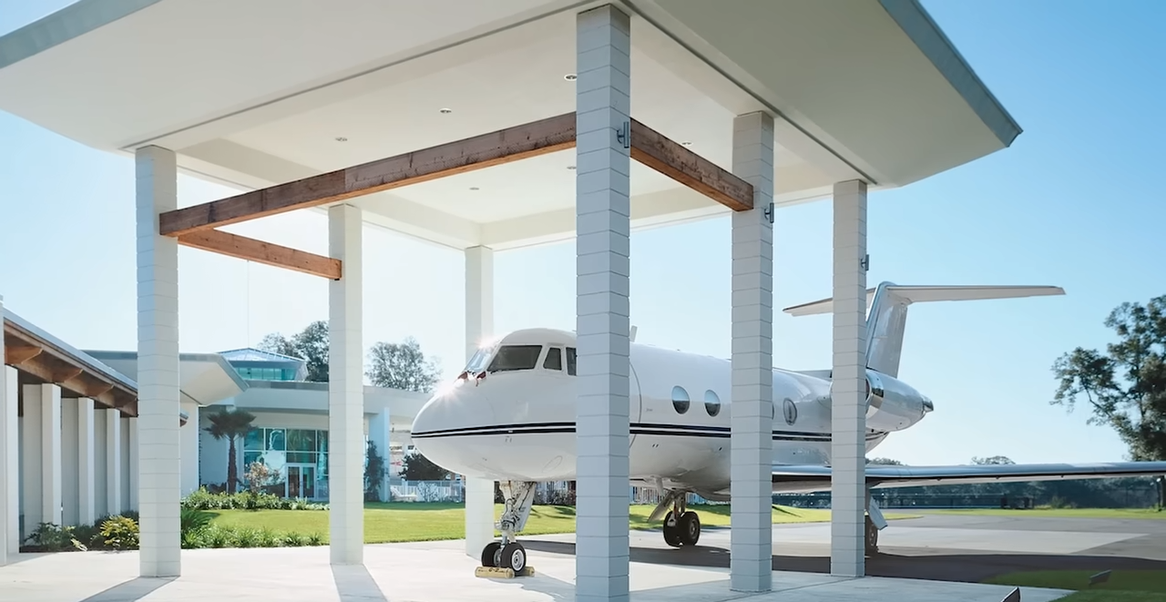 A private jet sits beneath a covered plane pavilion beside the home, illustrating how closely aviation was incorporated into the property's design. | Source: YouTube/@Therichest