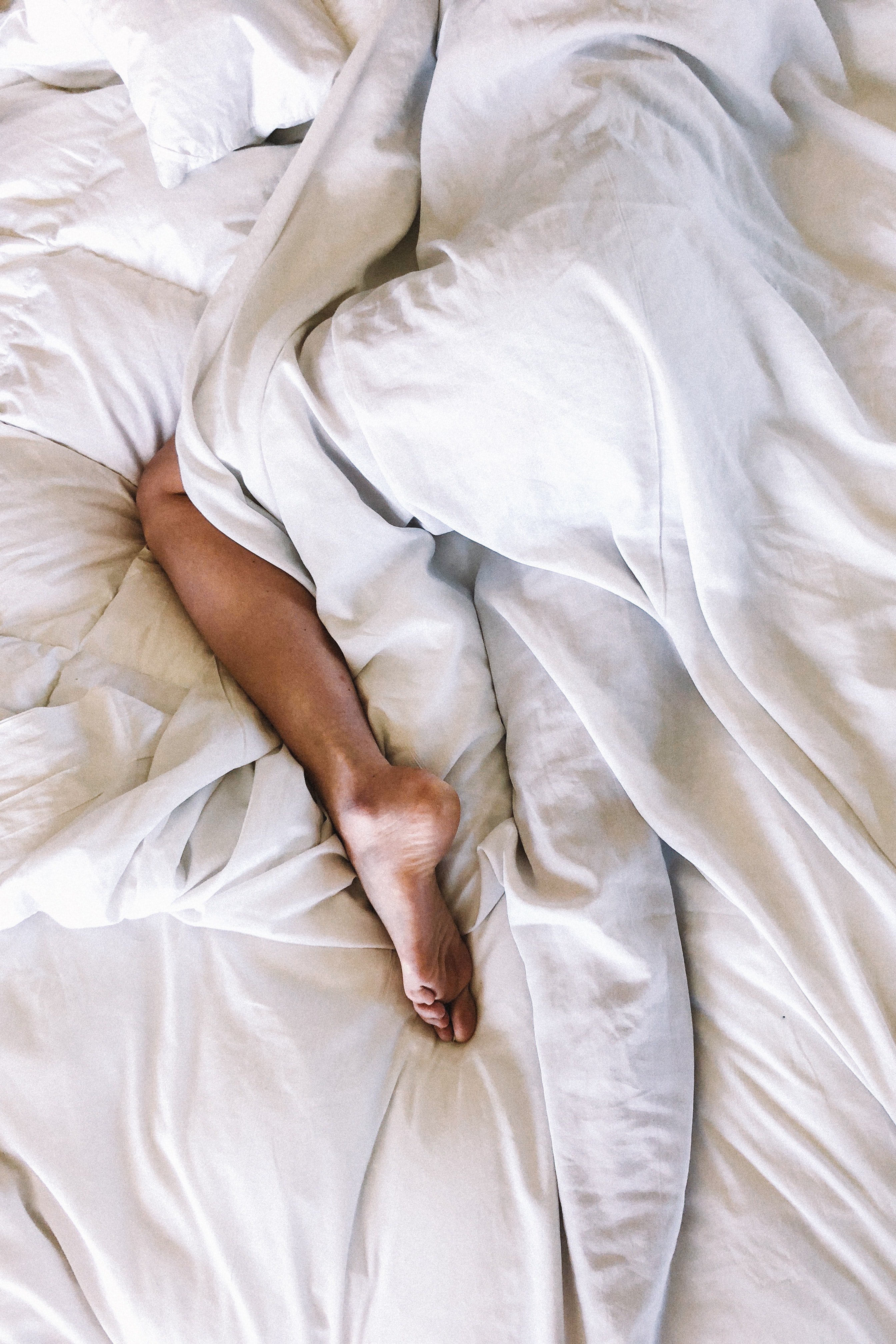 Woman's legs in bed | Unsplash