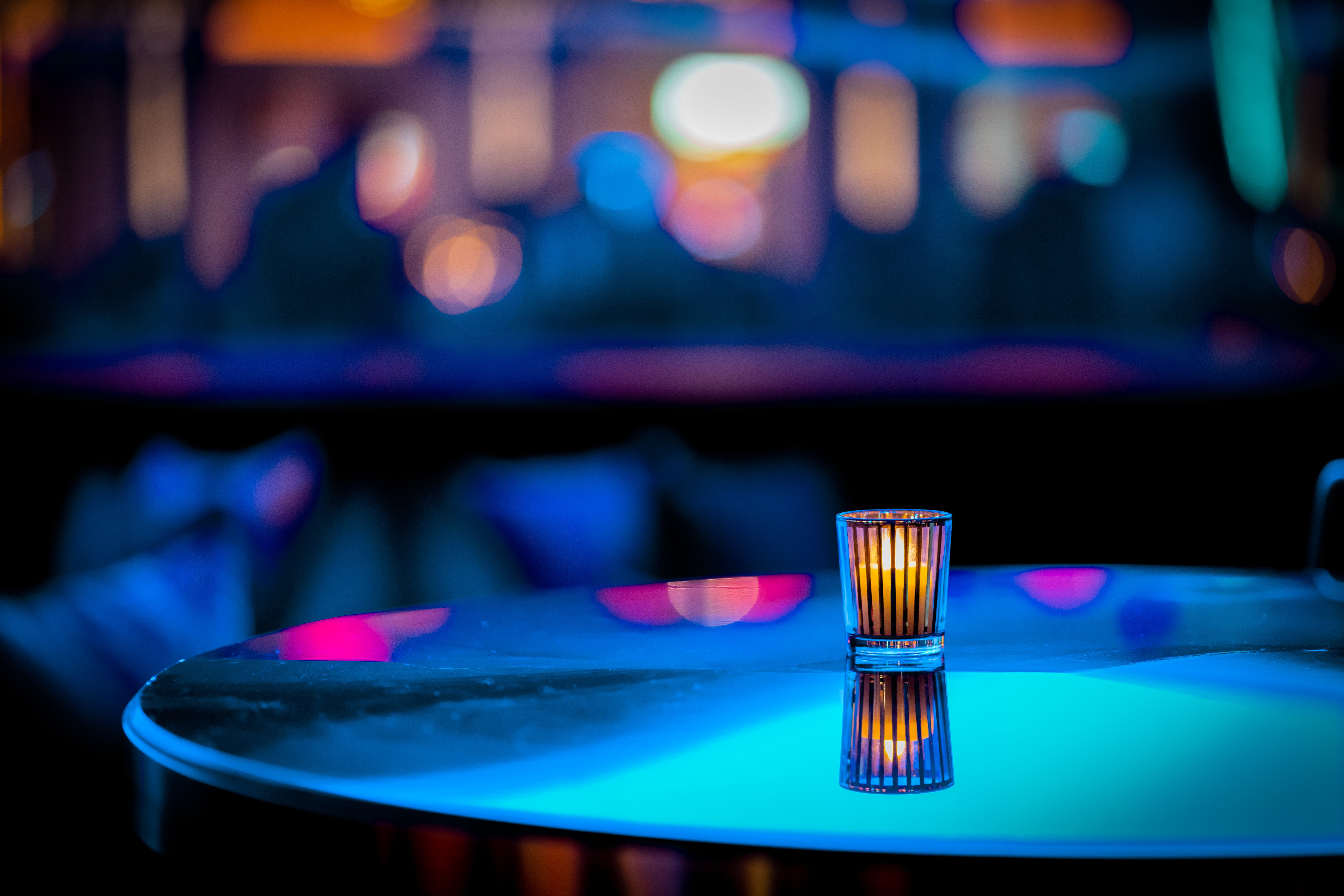 A photo of a minimalistic candle on table at a nightclub with an out of focus background | Source: Getty Images