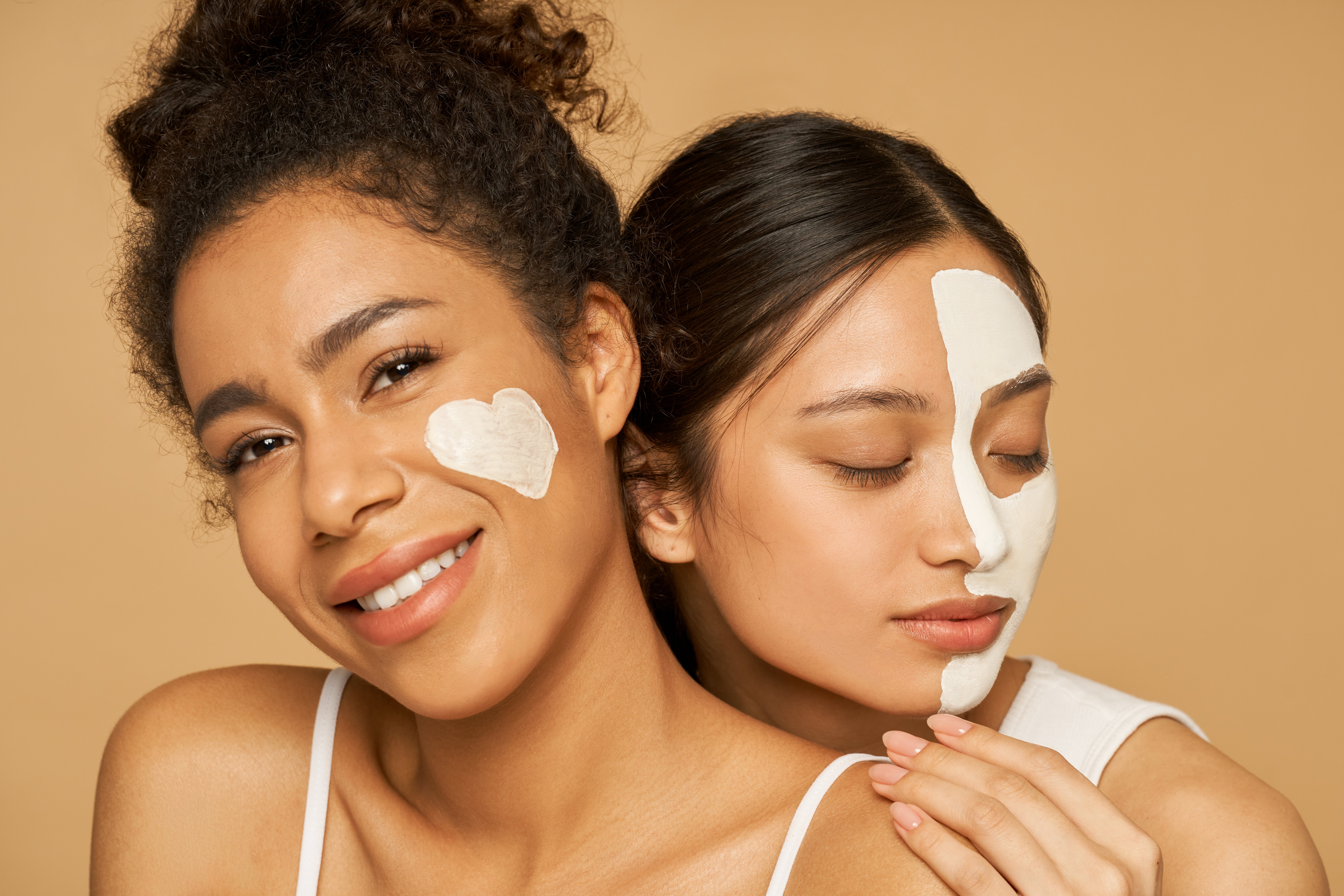 Women with lotion on their faces | Shutterstock 