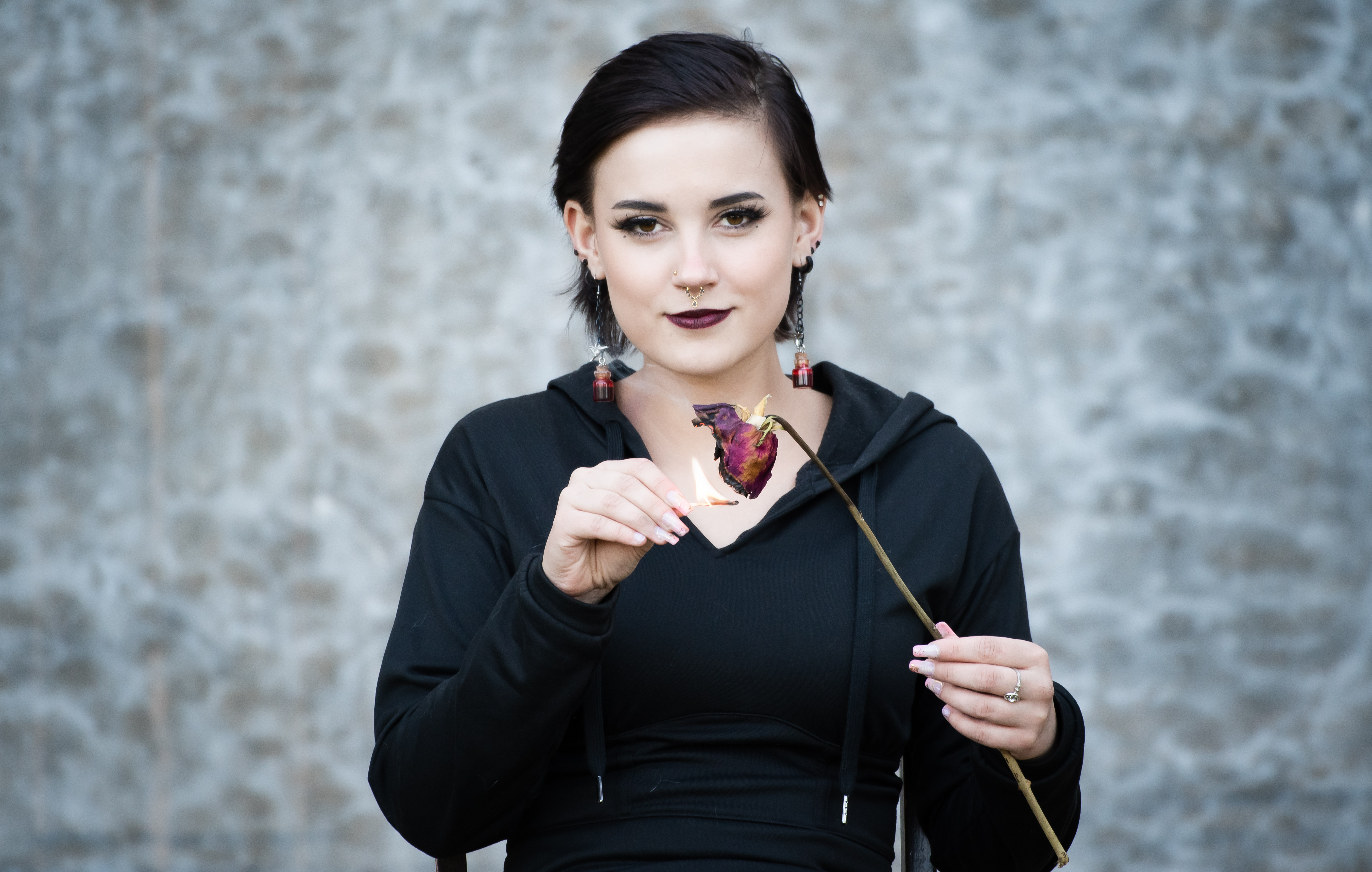 A portrait of a teenage girl holding a match to a rose | Source: Getty Images