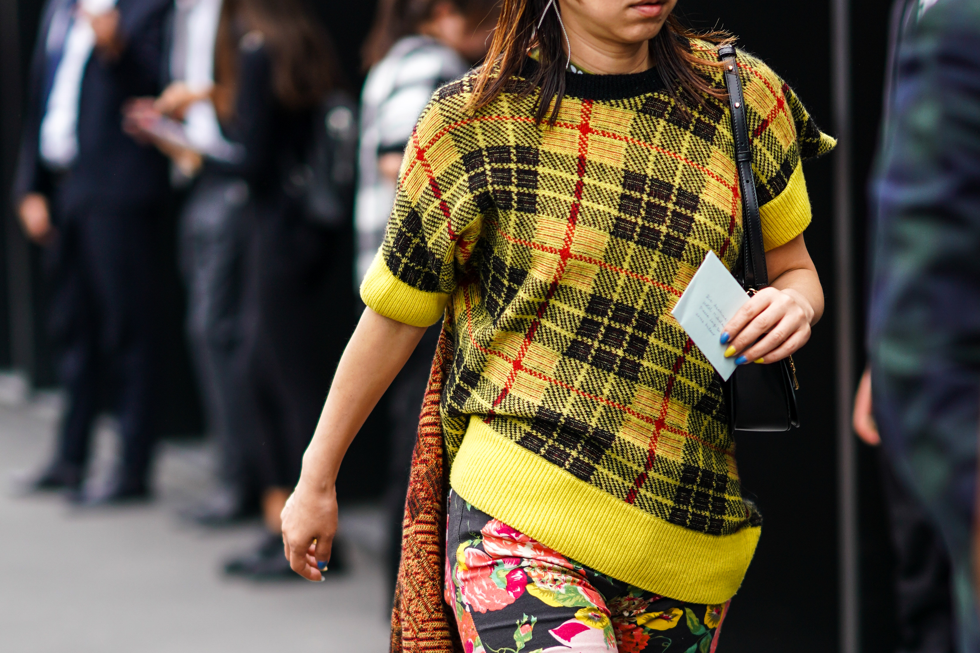 A person wearing a yellow, black and red plaid sweater paired with floral print pants outside the Gucci show during Milan Fashion Week Spring/Summer 2020 on September 22, 2019 | Source: Getty Images
