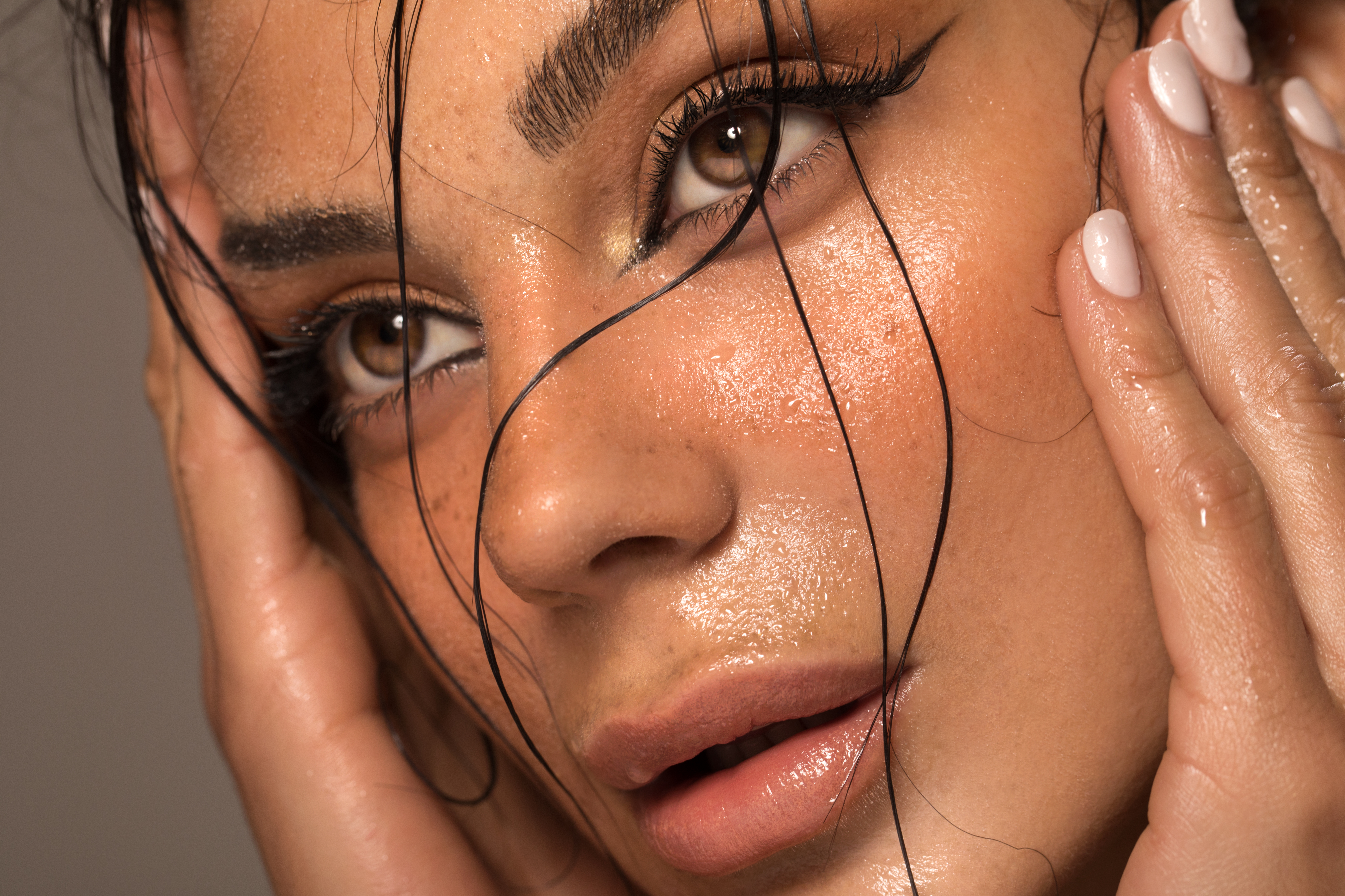 A woman with a wet makeup look holding her face | Source: Getty Images