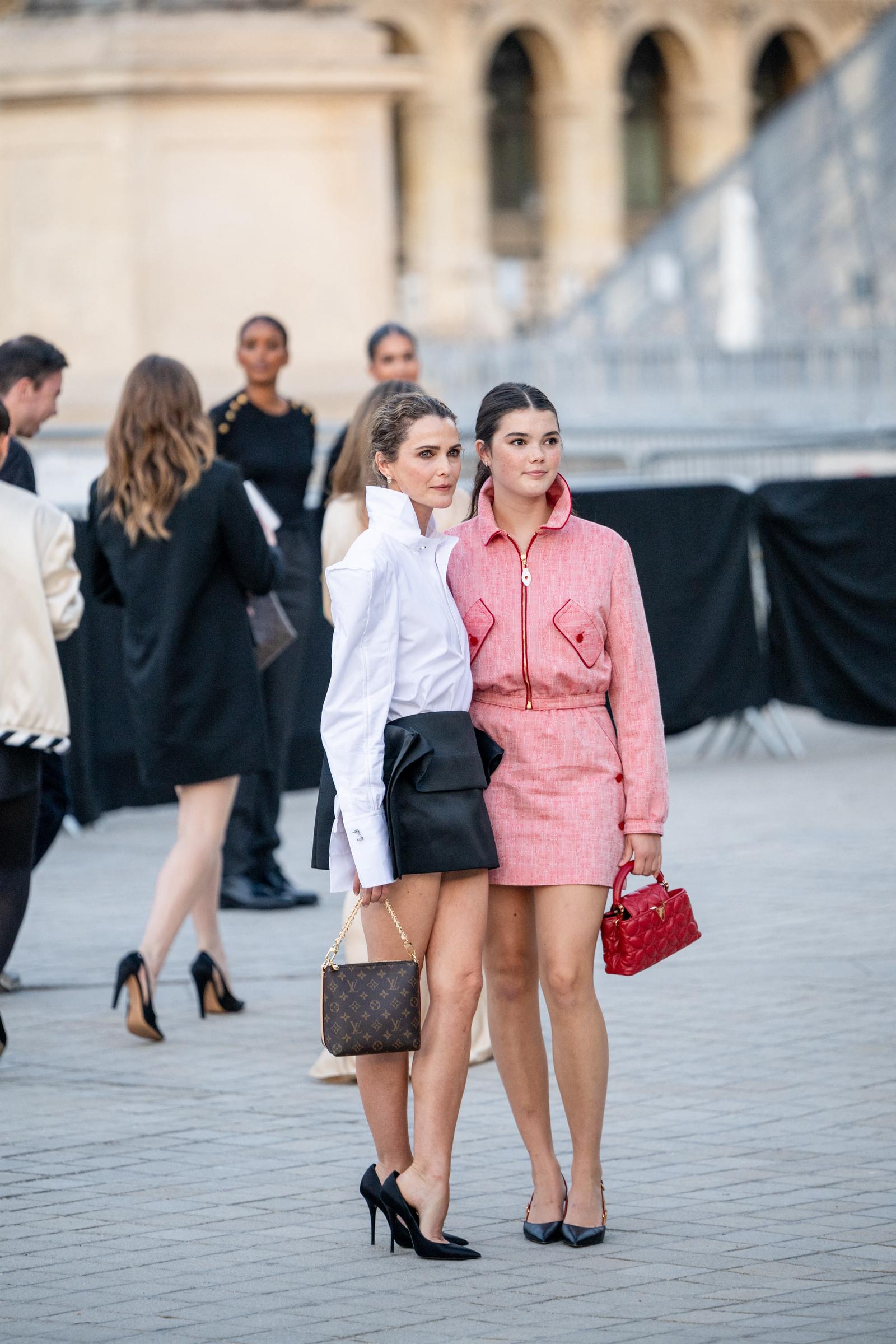 This wider Paris shot shows Keri and Willa pausing together near the Louvre, with Willa’s bright pink set standing out against her mother’s black-and-white look as photographers gathered around the show. | Source: Getty Images
