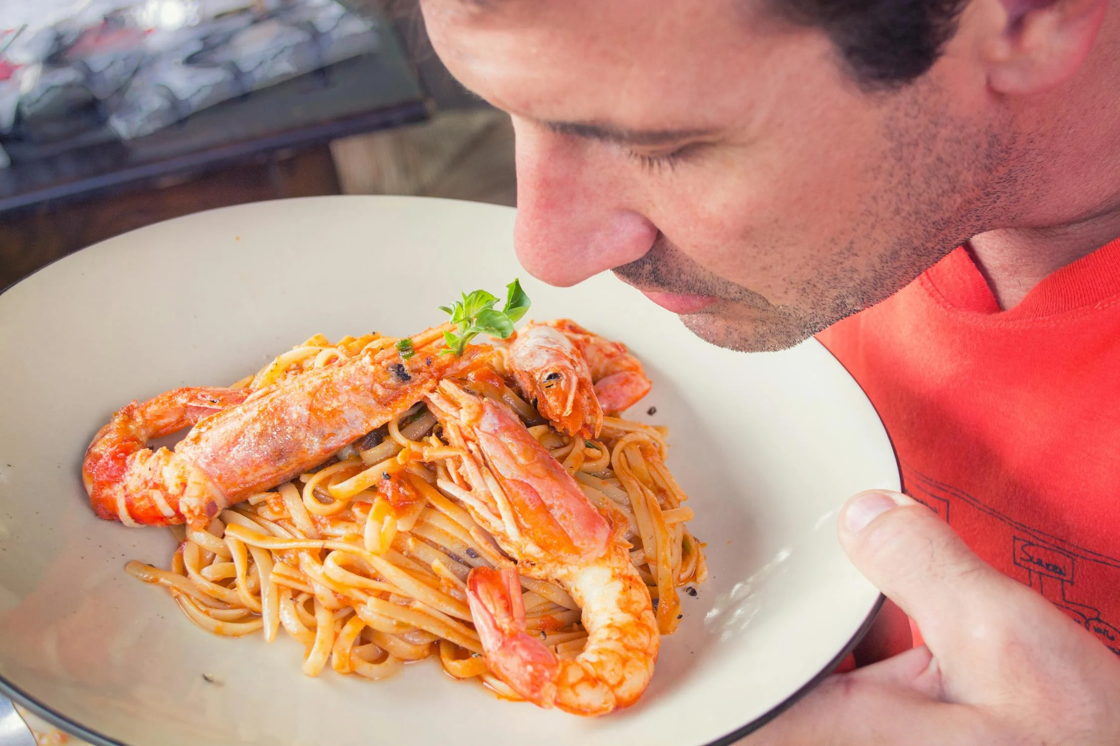 Um homem cheirando macarrão | Fonte: Pexels