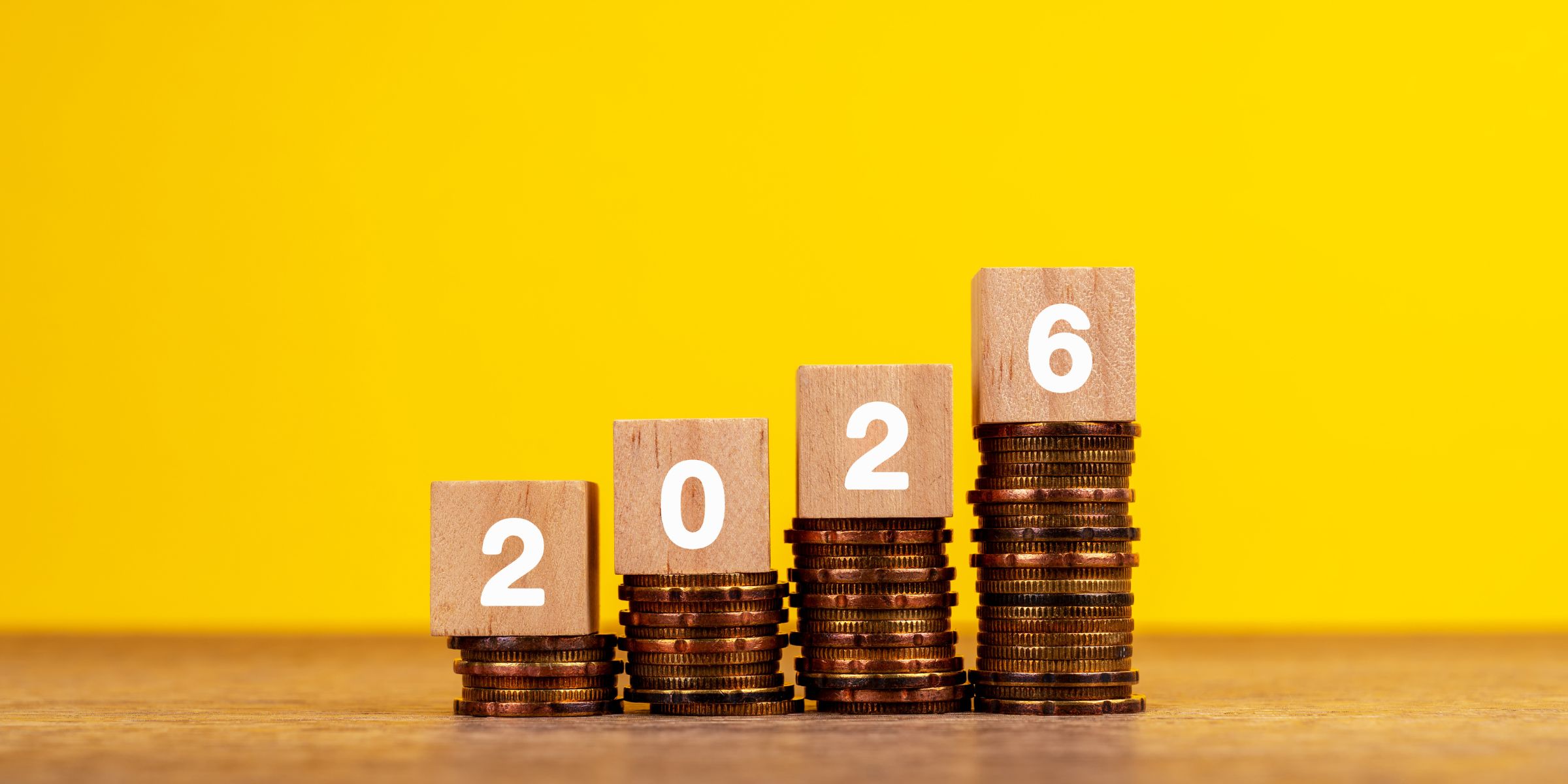 2026 in wooden blocks placed on stacks of coins | Source: Getty Images
