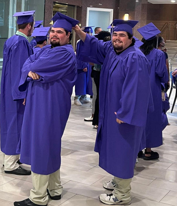 Kenny Rogers' twin sons, Justin and Jordan, celebrate their high school graduation in vibrant purple caps and gowns in June 2023. The brothers show off their playful bond in the ceremony hall as one stands with arms crossed while the other grins widely and adjusts his sibling's mortarboard. | Source: Instagram/_kennyrogers