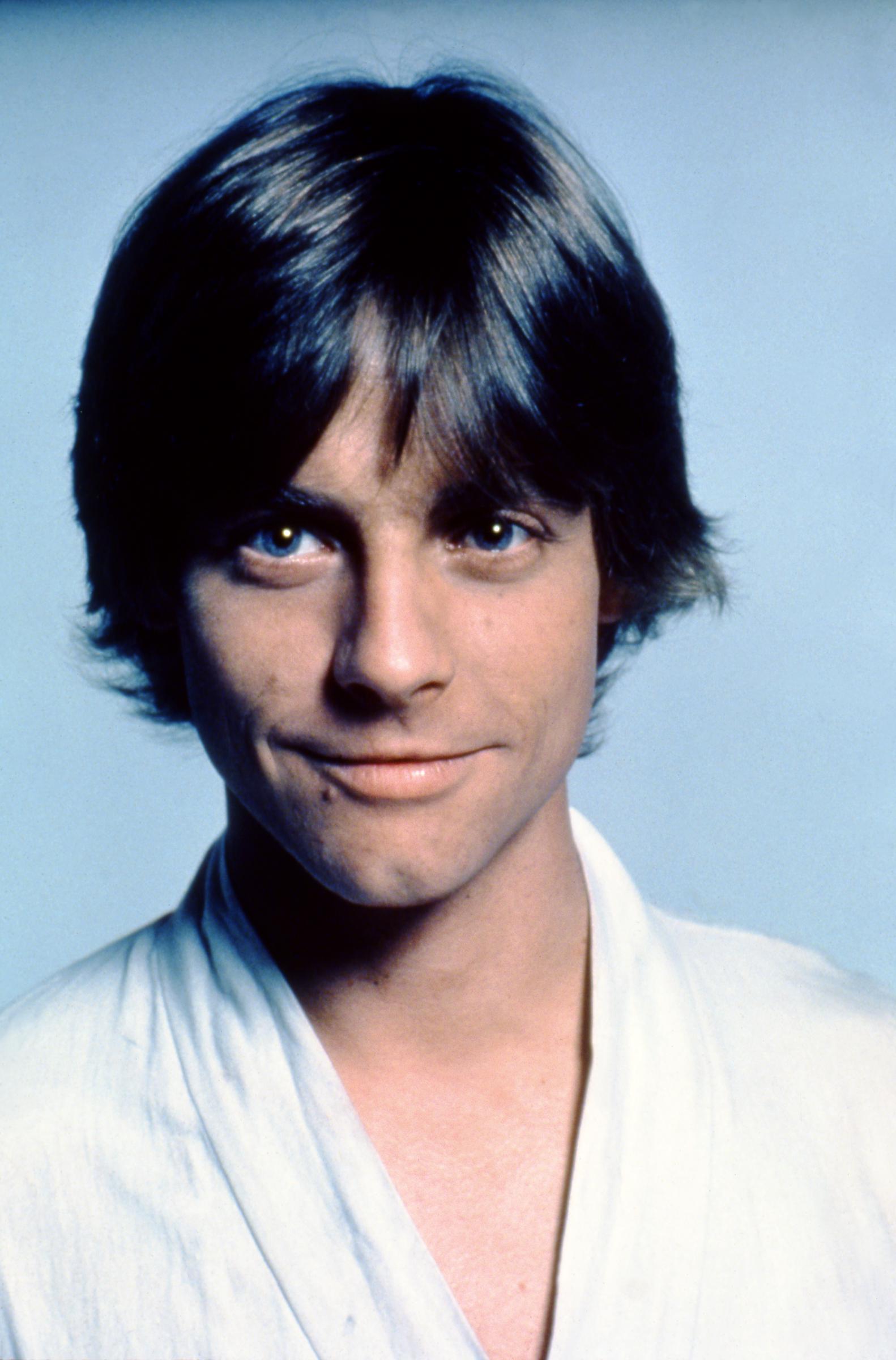 A close-up portrait of Mark Hamill as Luke Skywalker during production of "Star Wars: A New Hope" offered a detailed view of the actor before the film became a worldwide phenomenon. With his dark hair framing his face and Luke's white costume visible, Hamill was still months away from sudden fame. The portrait also documented his features before the 1977 crash that fractured two facial bones and required reconstruction. | Source: Getty Images