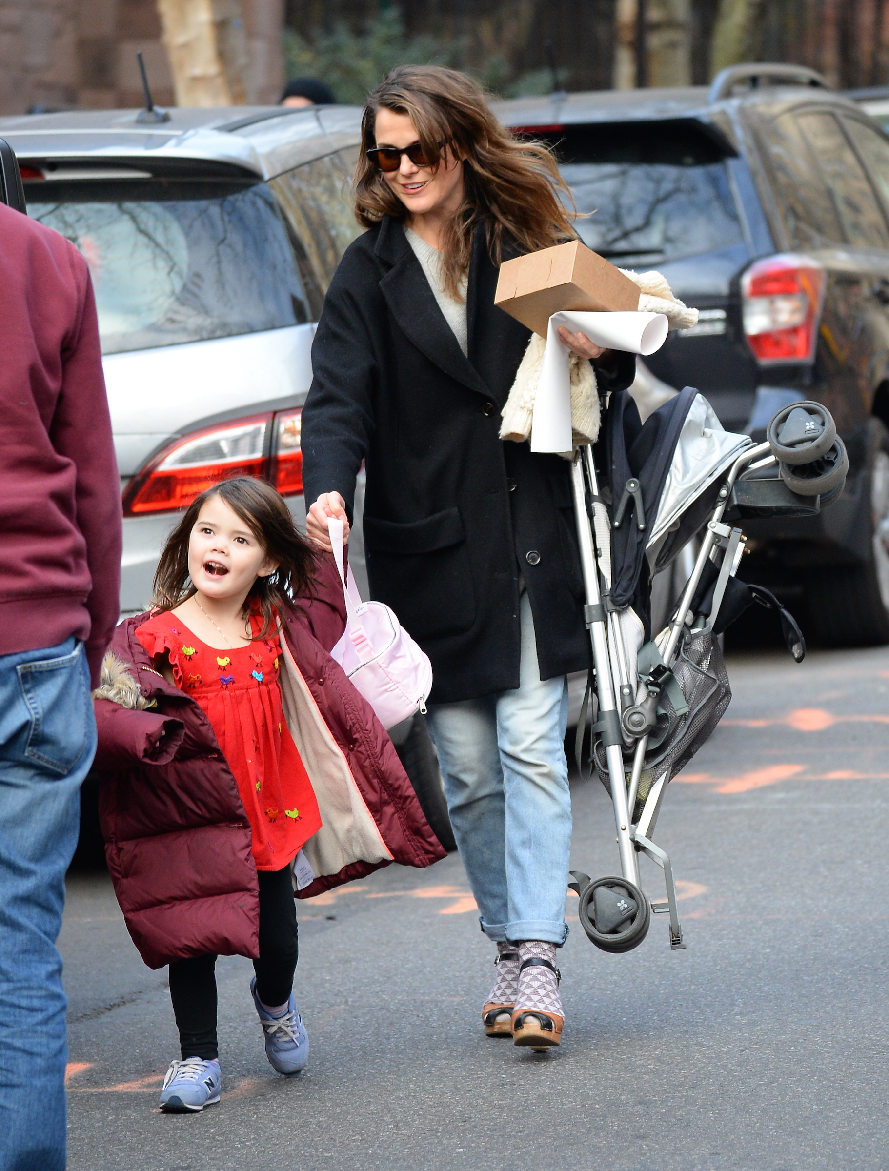 This street photo shows the everyday side of their early years together, with Willa walking hand in hand beside her mother and a folded stroller in tow — years before their polished Paris Fashion Week appearance. | Source: Getty Images