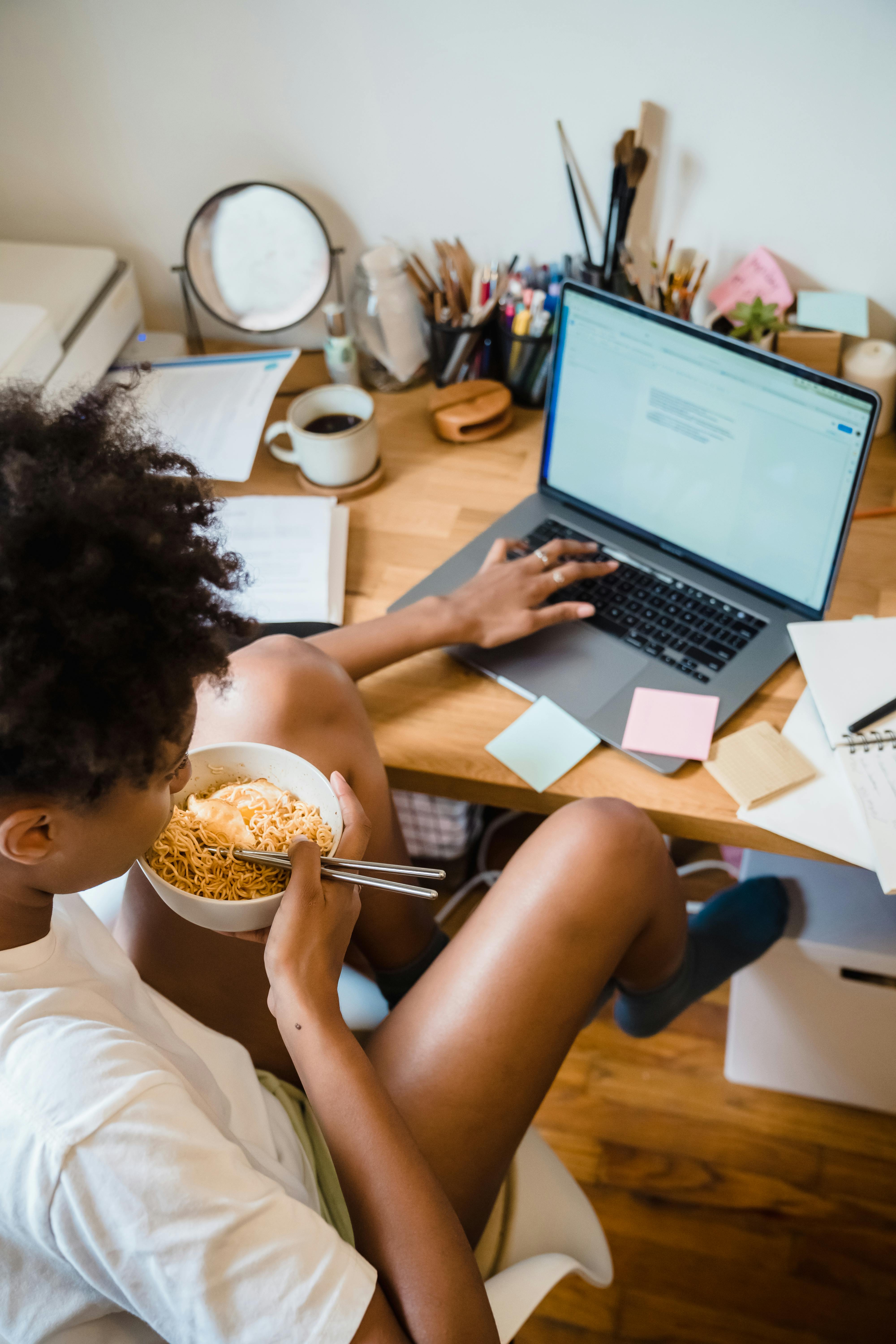 A woman eating while working | Source: Pexels