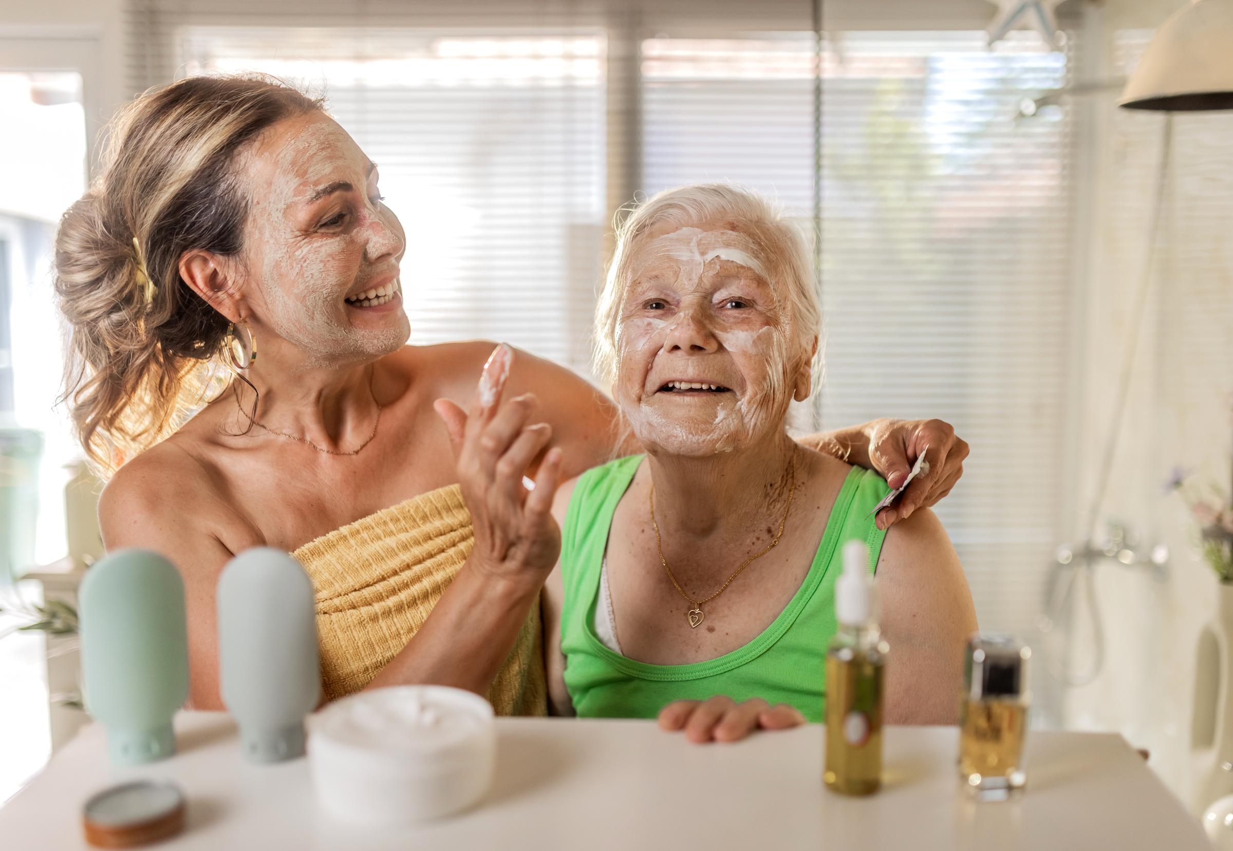 An older woman and her mother enjoy a skincare routine together in a bathroom | Source: Getty Images
