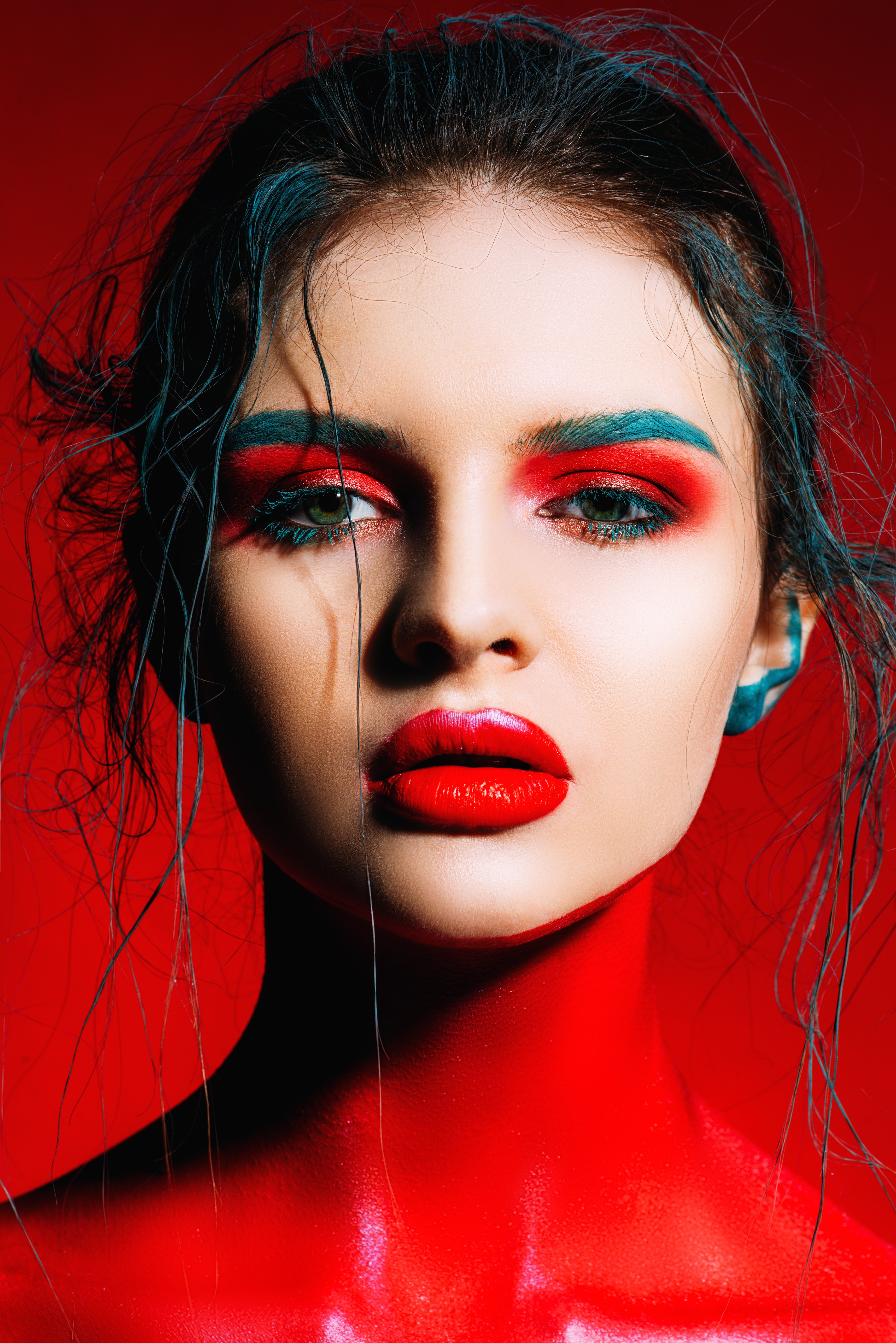 A close-up portrait of a young woman with creative makeup and body painting | Source: Shutterstock