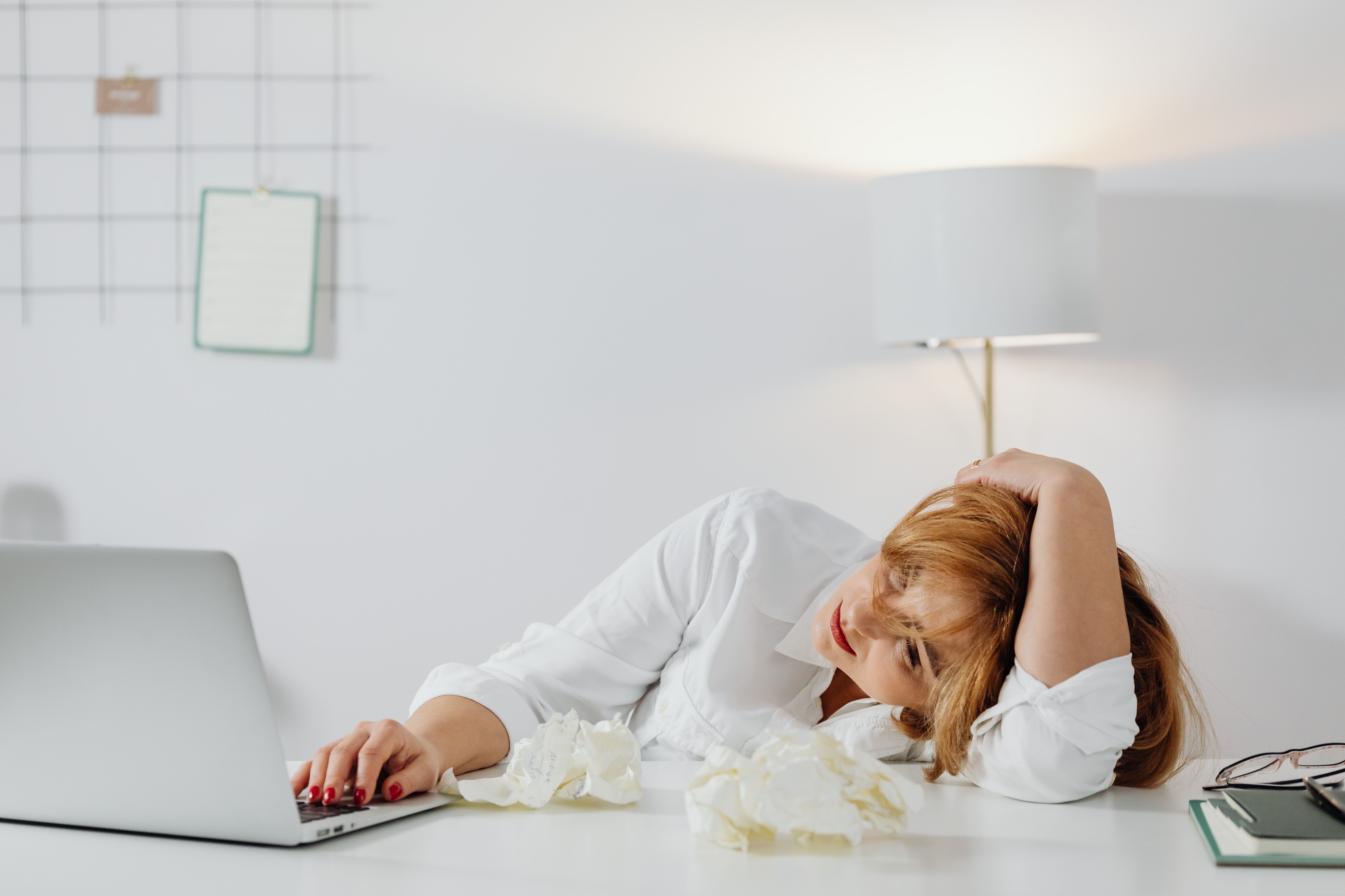 Woman resting her head on a table, exhausted at work | Source: Pexels