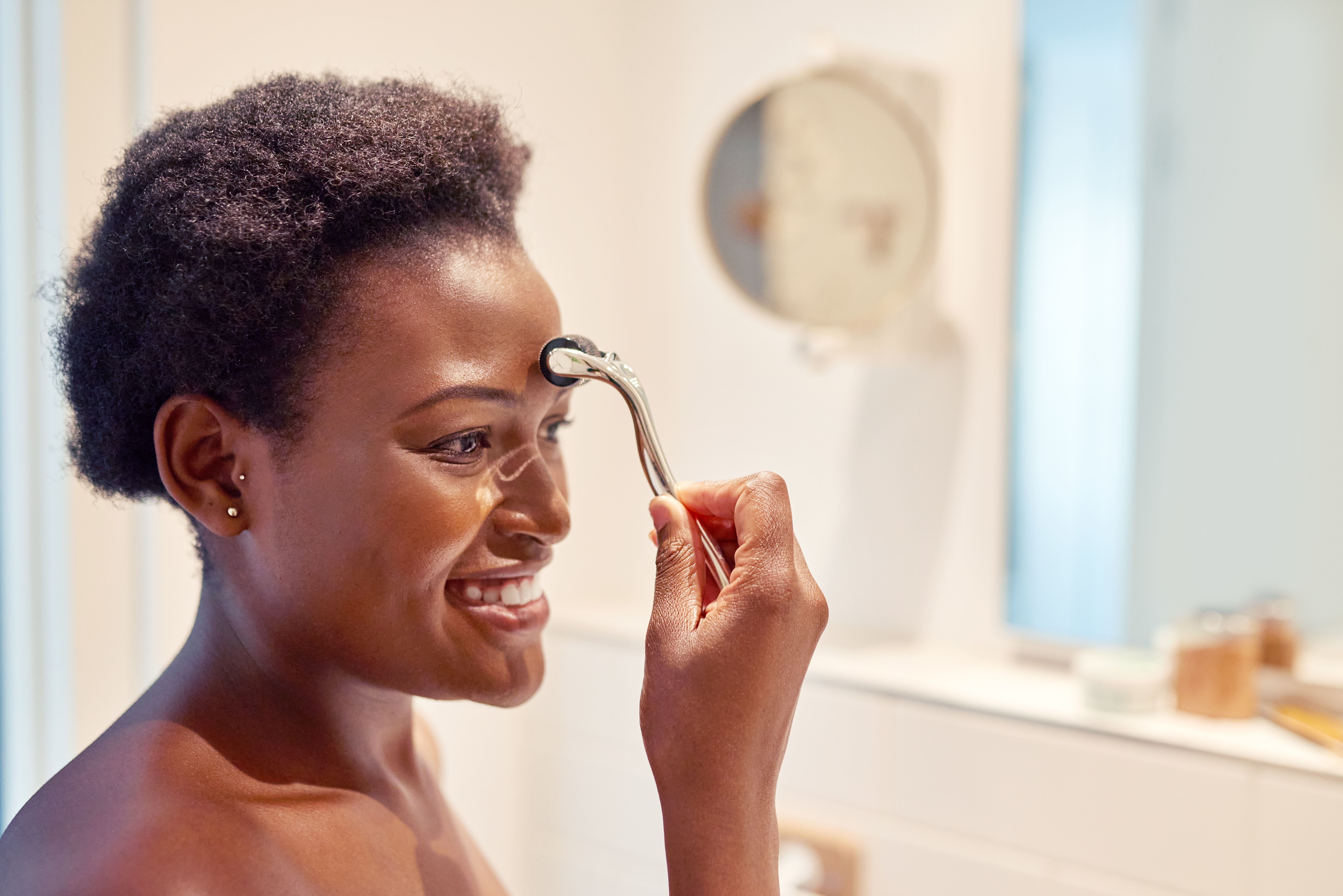 A woman using dermarollers in between her eyebrows | Source: Getty Images