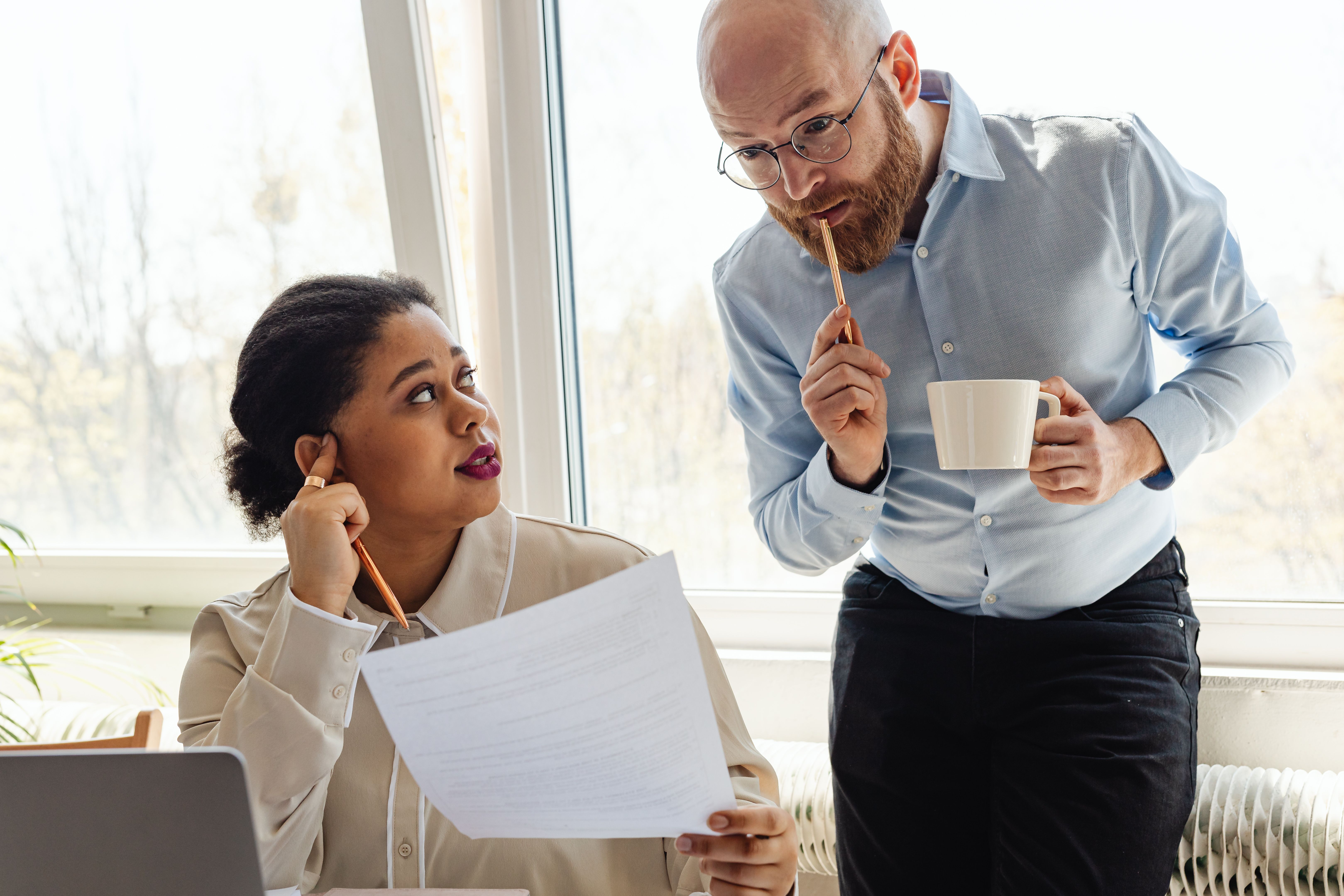 A woman speaking to a coworker who appears confused | Source: Pexels