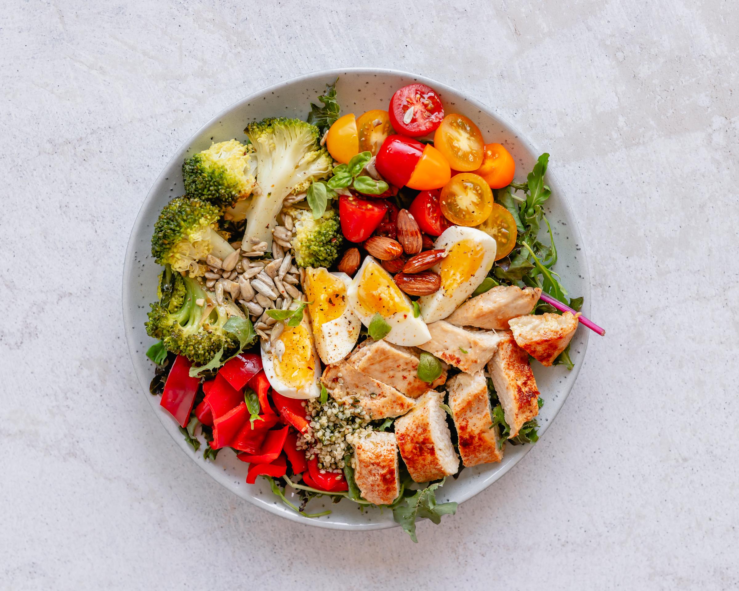 A healthy bowl of food filled with veggies, chicken, eggs and almonds | Source: Getty Images