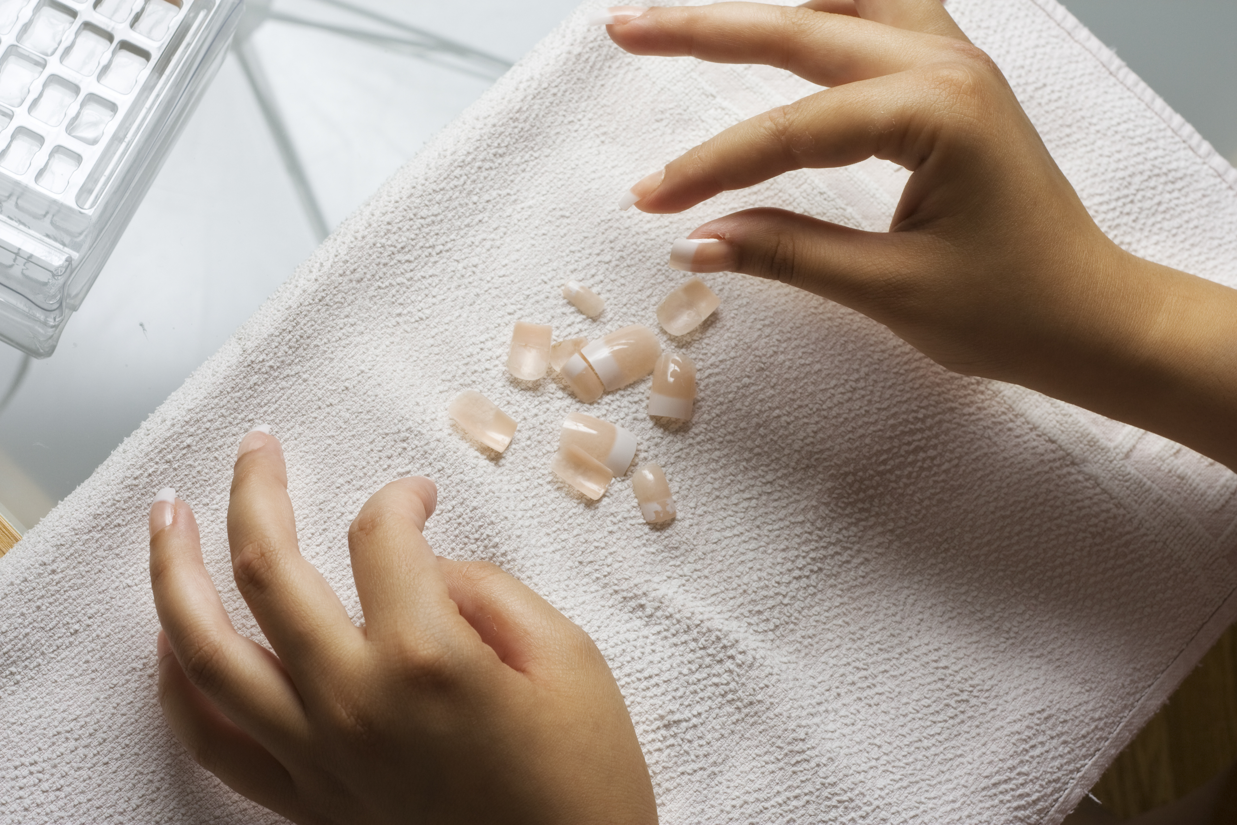 A woman applying press-on nails. | Source: Getty Images