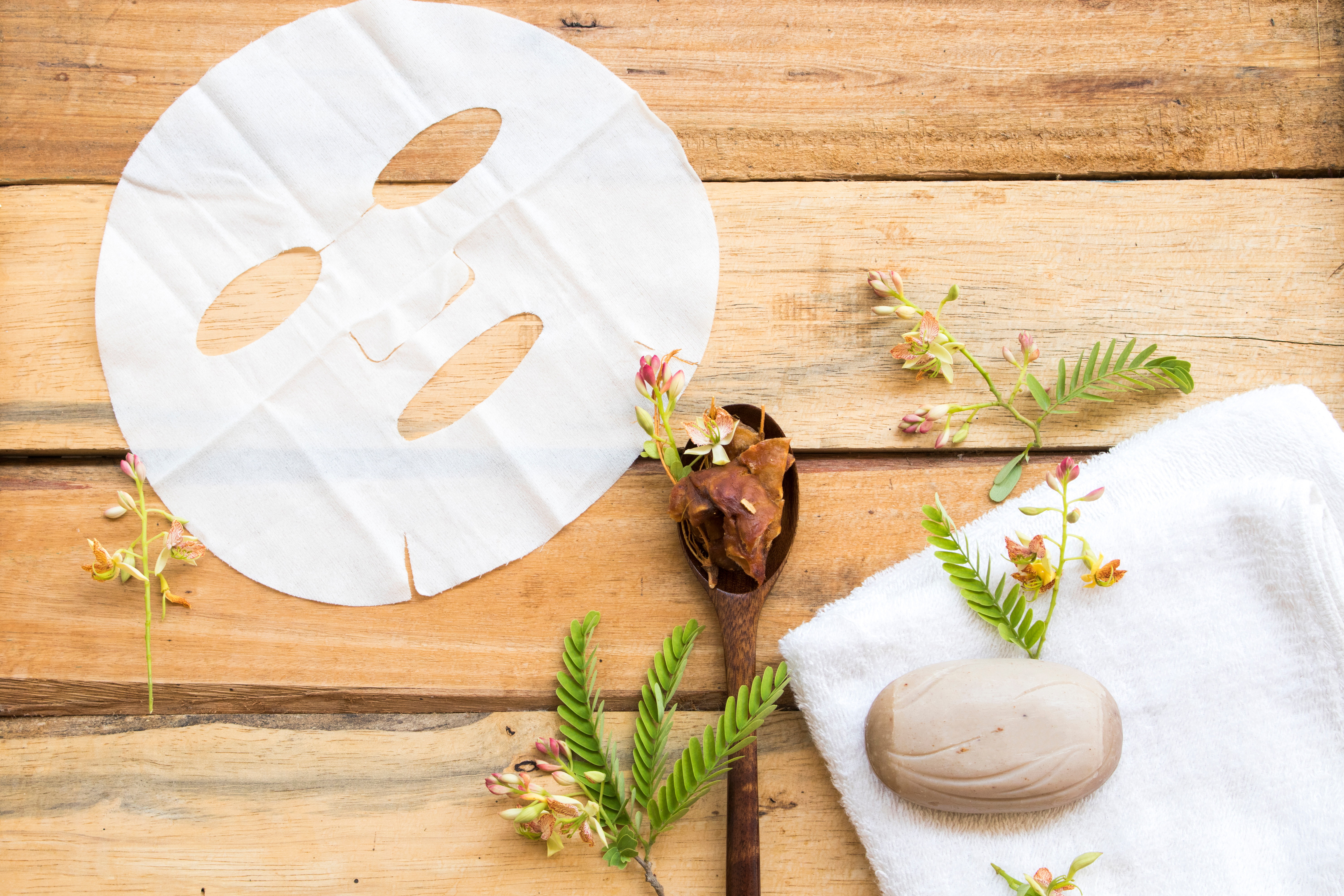 A flat lay of sheet mask, flowers, and soap. | Source: Shutterstock