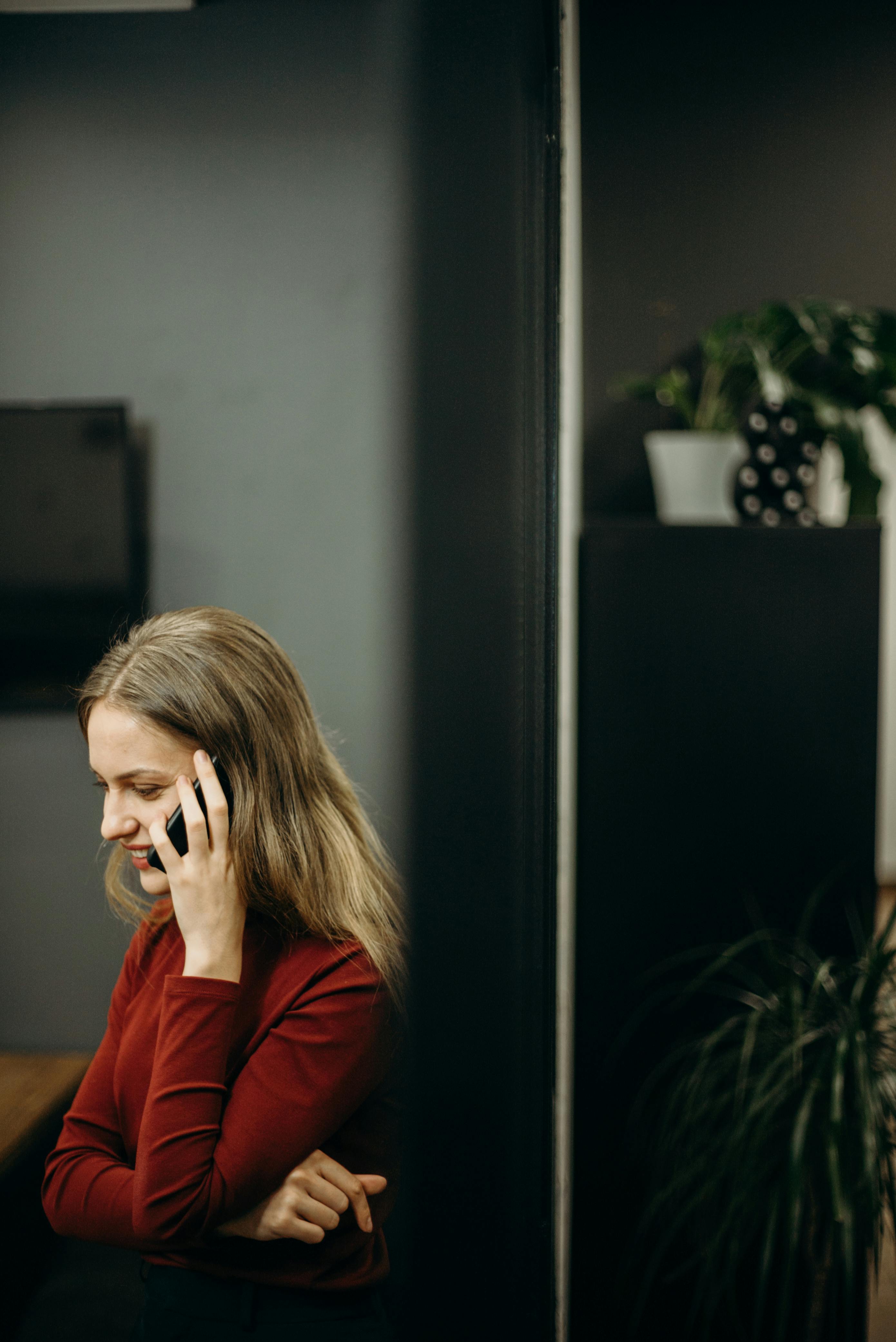 A smiling woman on her phone | Source: Pexels