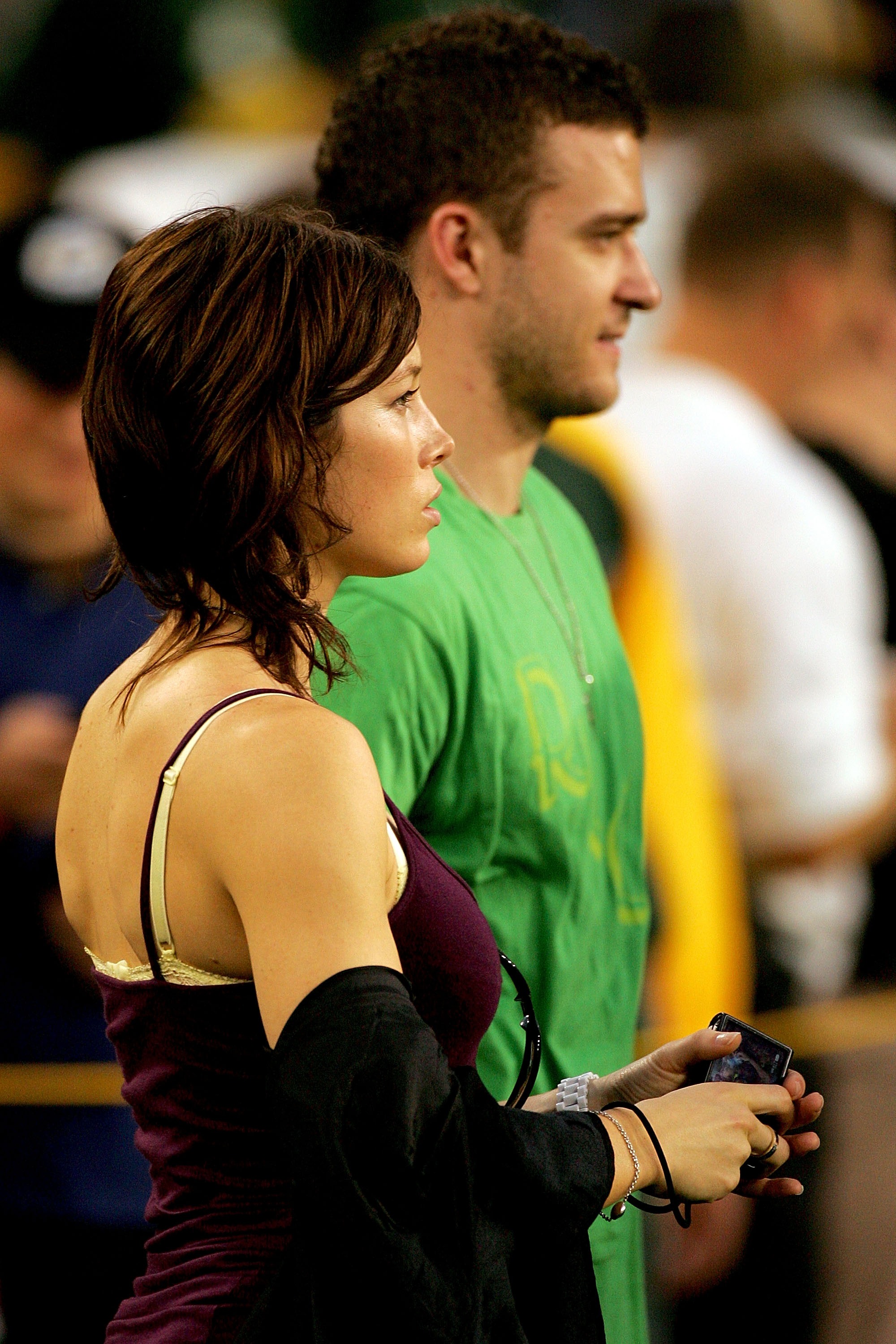 Jessica Biel and Justin Timberlake watch an event together, with Biel holding a small device while seated beside Timberlake in a green T-shirt. | Source: Getty Images