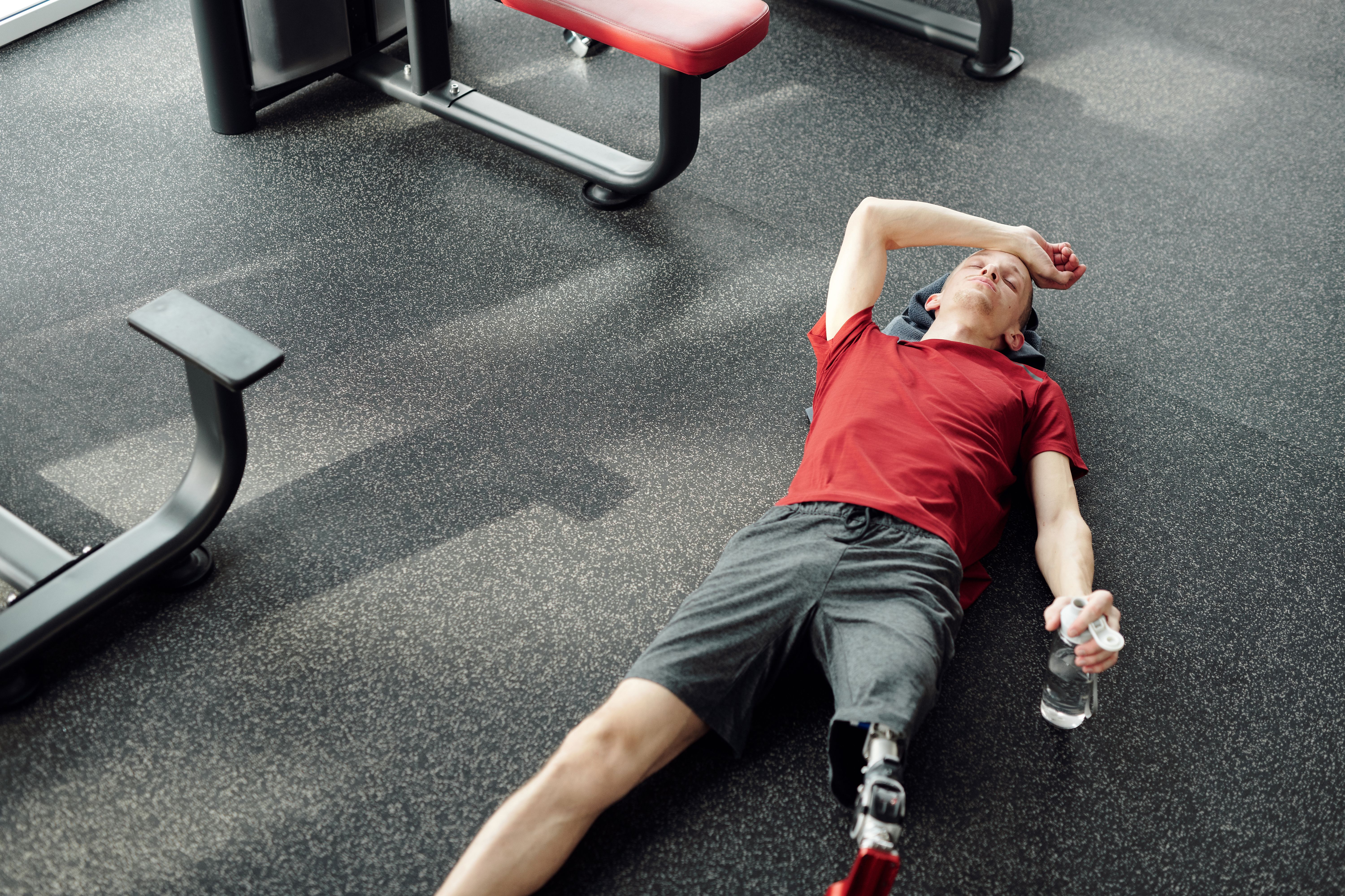 A man lying down on the floor of a gym | Source: Pexels