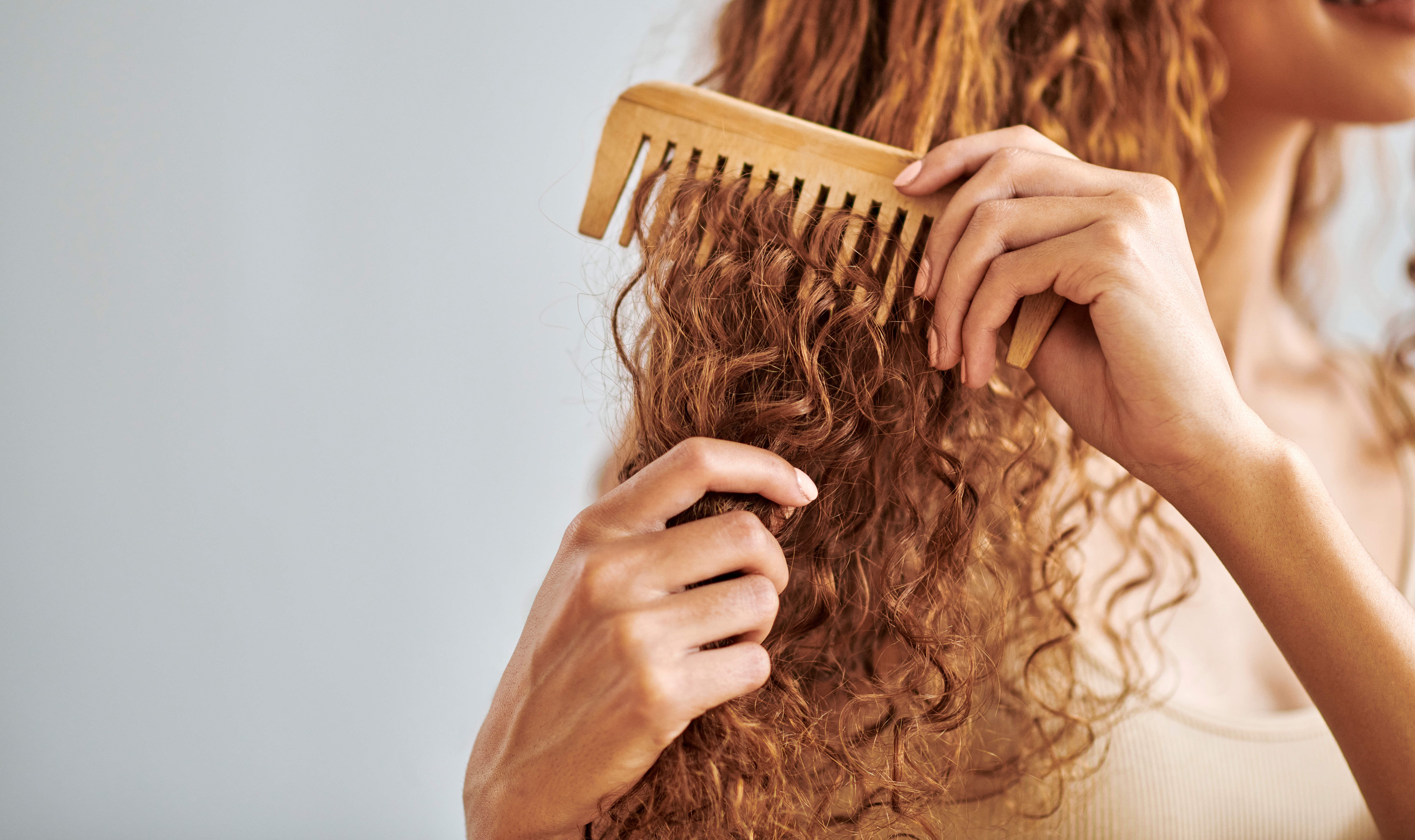 Woman caring for curly hair. | Source: Getty Images