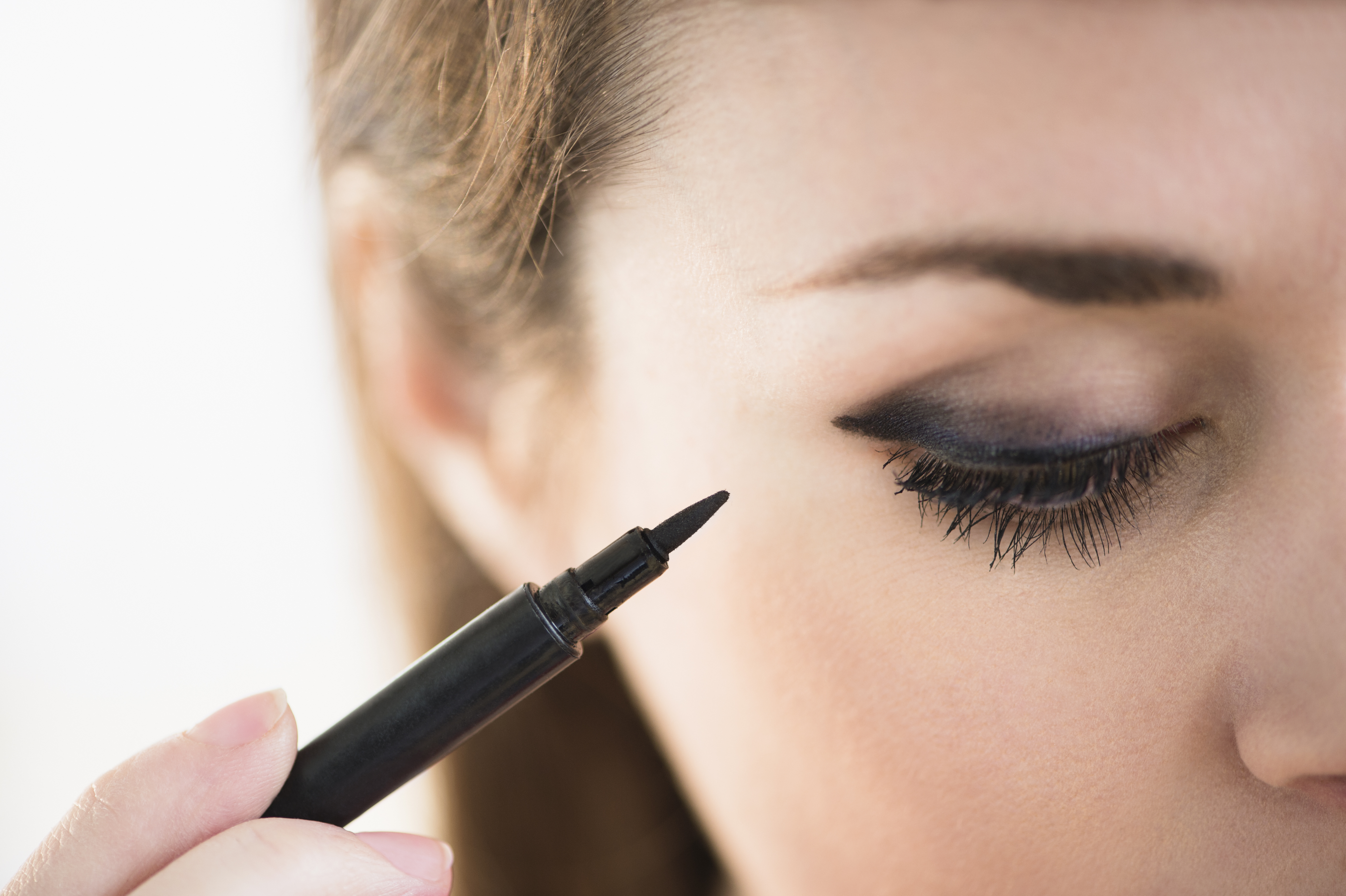 A woman applying black makeup. | Source: Getty Images