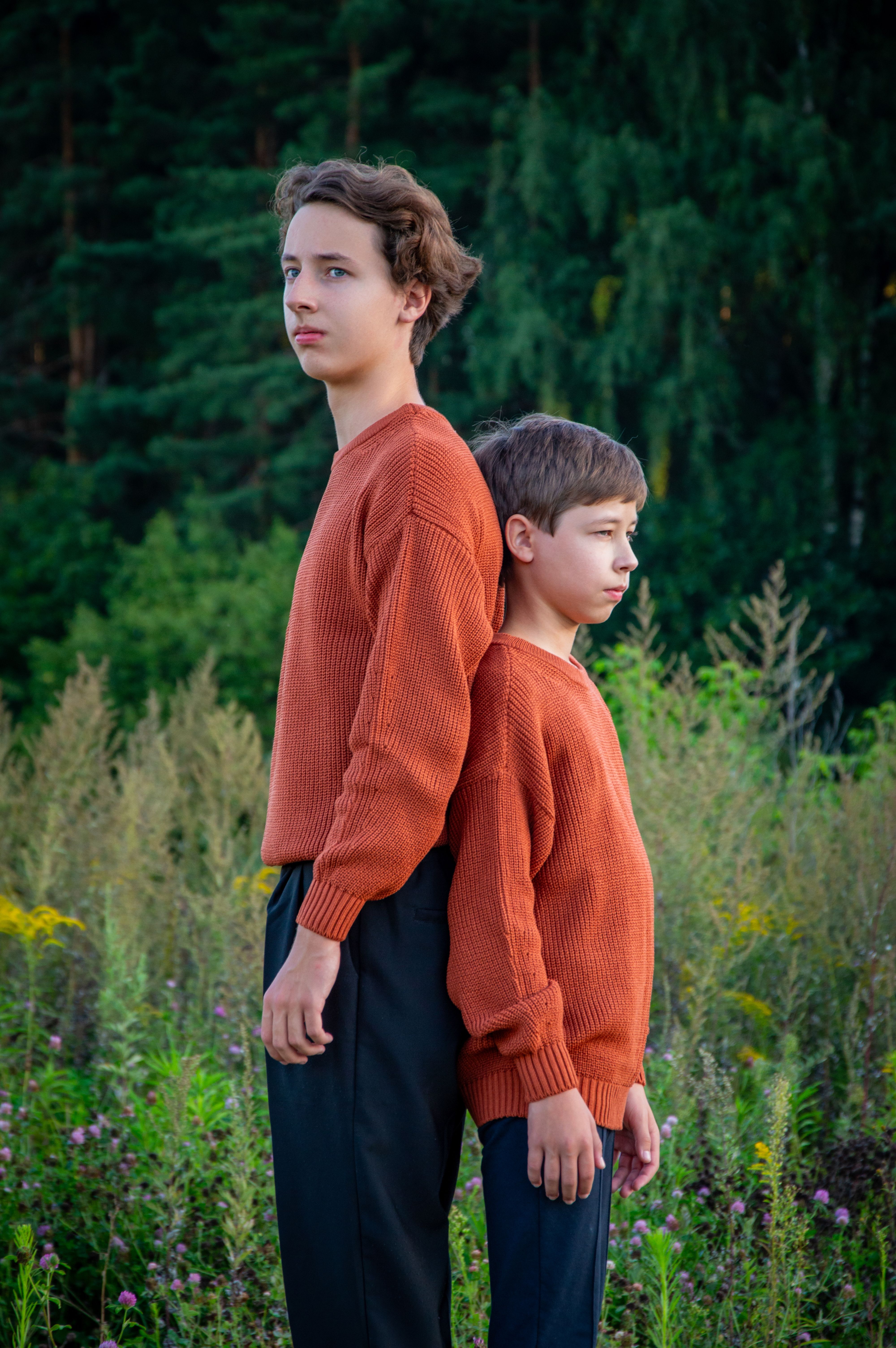 Two boys standing back to back, one a lot shorter than the other | Source: Pexels