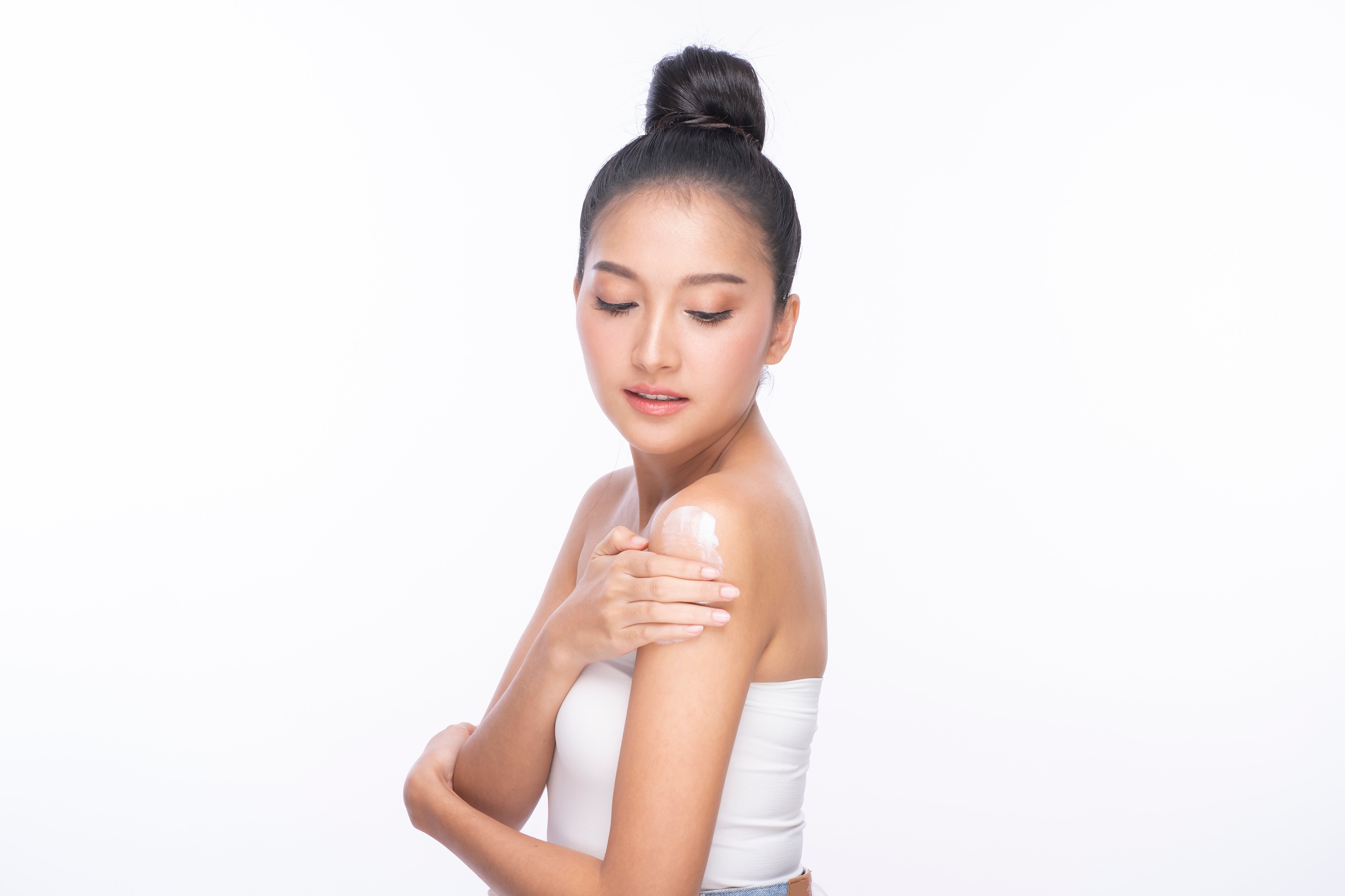 Photo of a woman moisturizing her skin | Source: Shutterstock