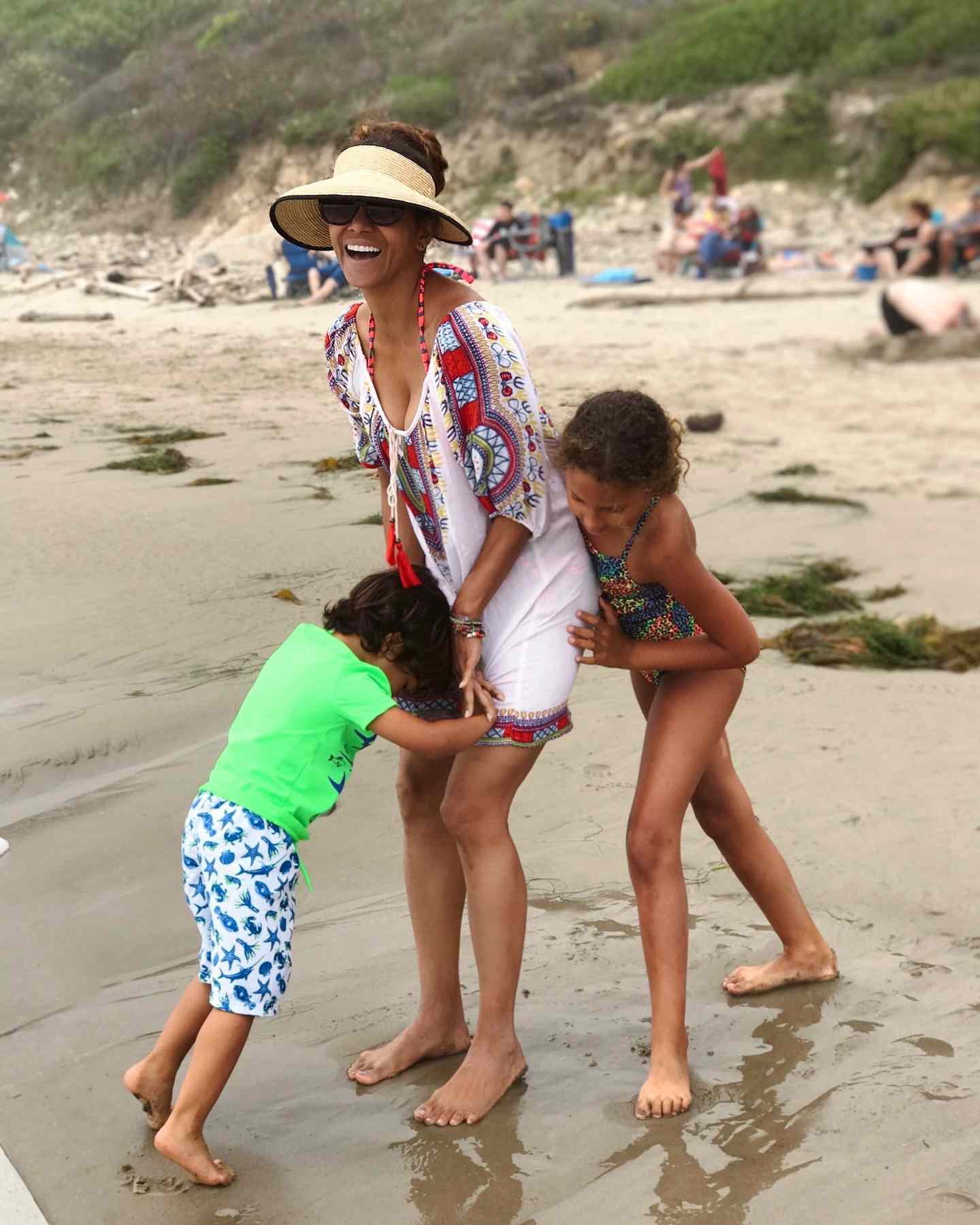 Halle Berry enjoyed a playful beach day with her two children, Nahla and Maceo, who are five years apart in age. The siblings were photographed laughing and clinging to their mother. | Source: Instagram via @halleberry