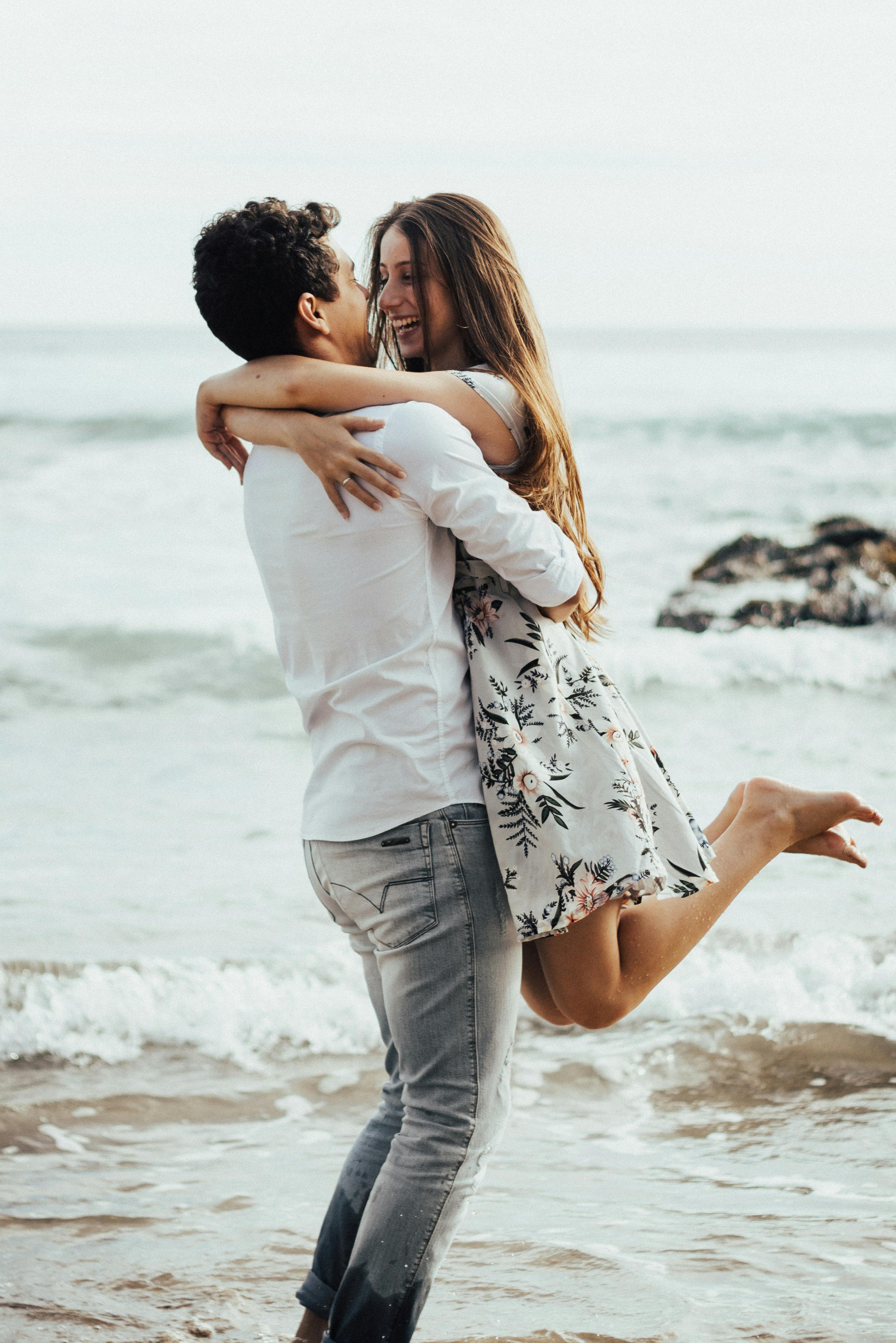 A smiling woman in a man's arms | Source: Pexels