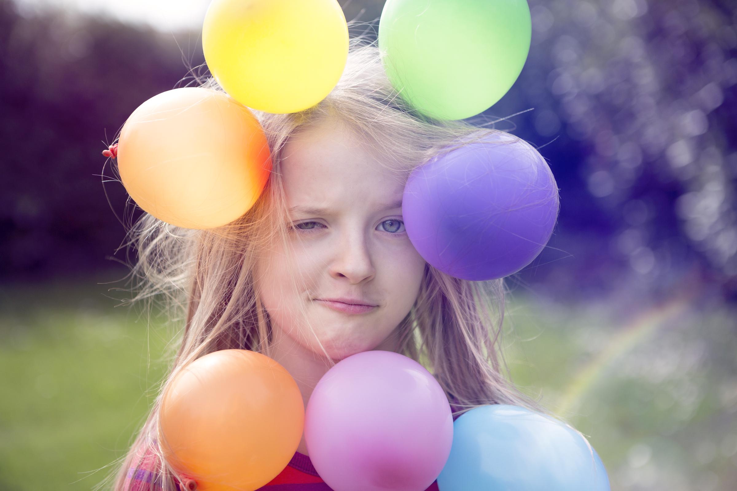 The effects of static electricity as demonstrated by balloons sticking to a child's hair | Source: Getty Images