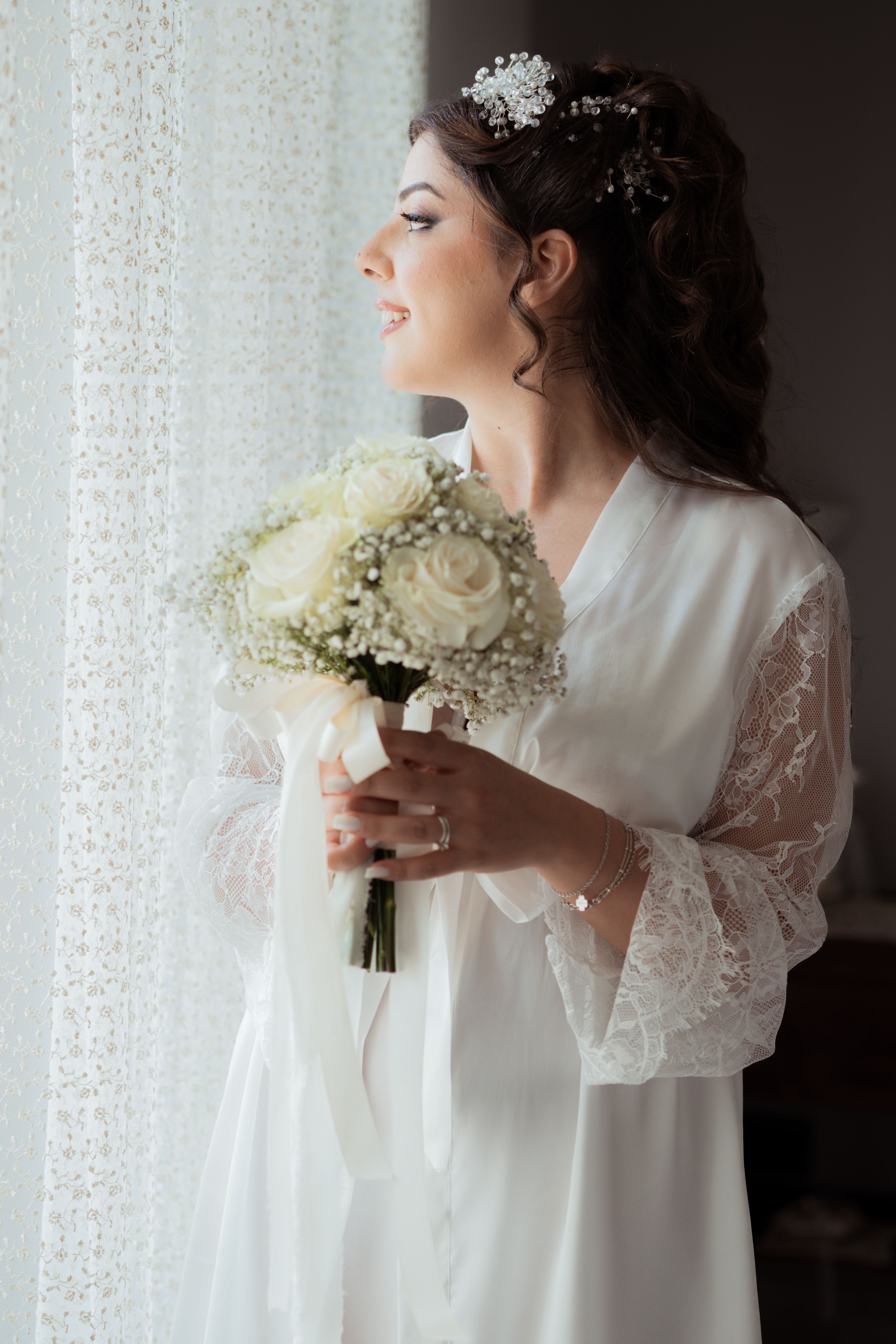 A bride dressed in a robe on her wedding day, looking out the window | Source: Pexels