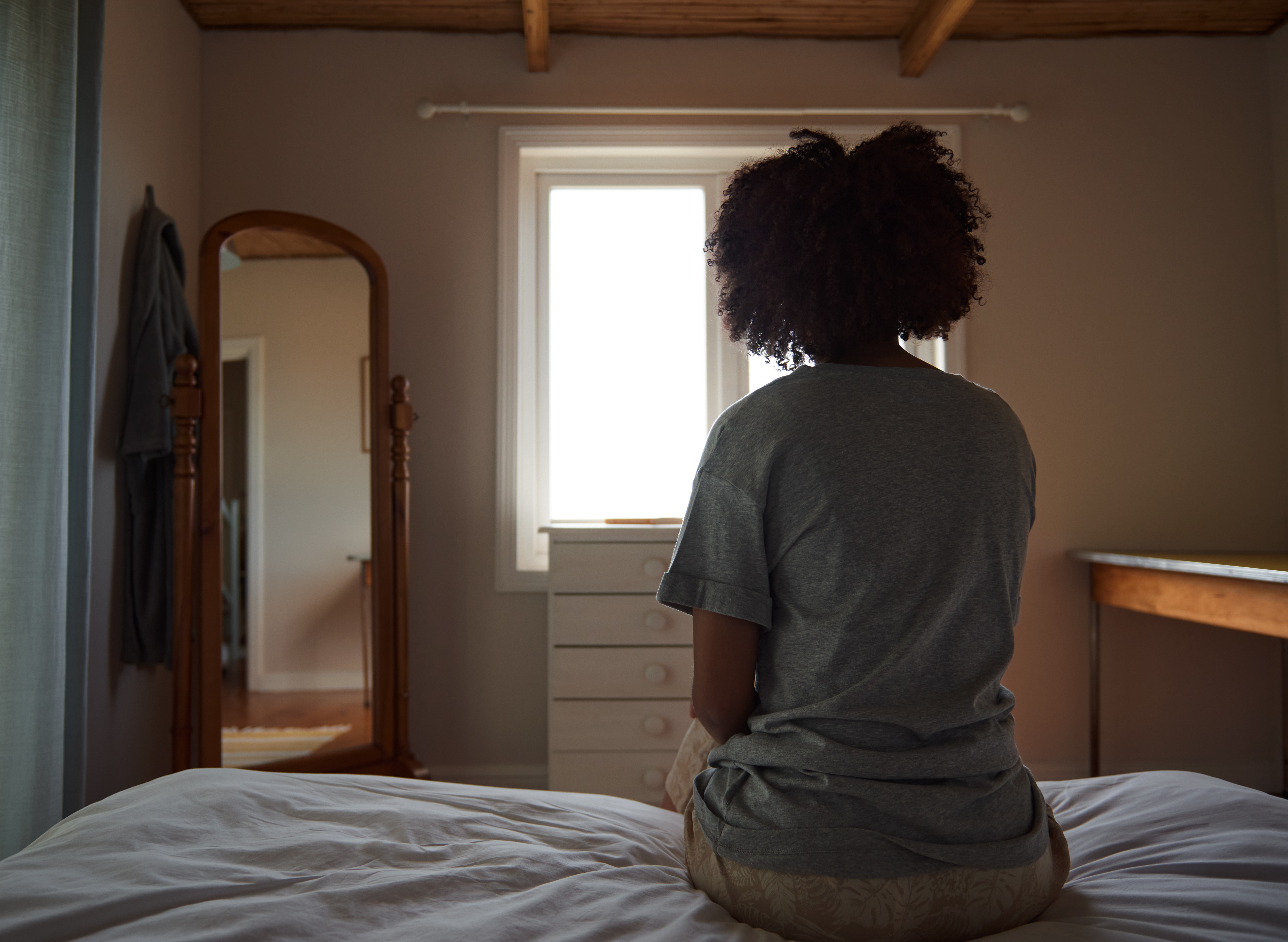 A woman sitting alone on her bed. | Source: Getty Images