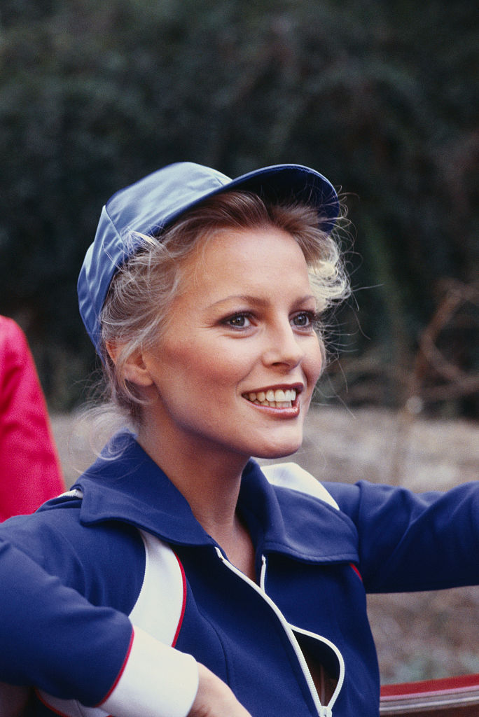 Cheryl Ladd smiles in a candid outdoor moment, wearing a sporty cap and jacket, her relaxed pose and natural glow capturing a playful side of the actress during her rising fame.
