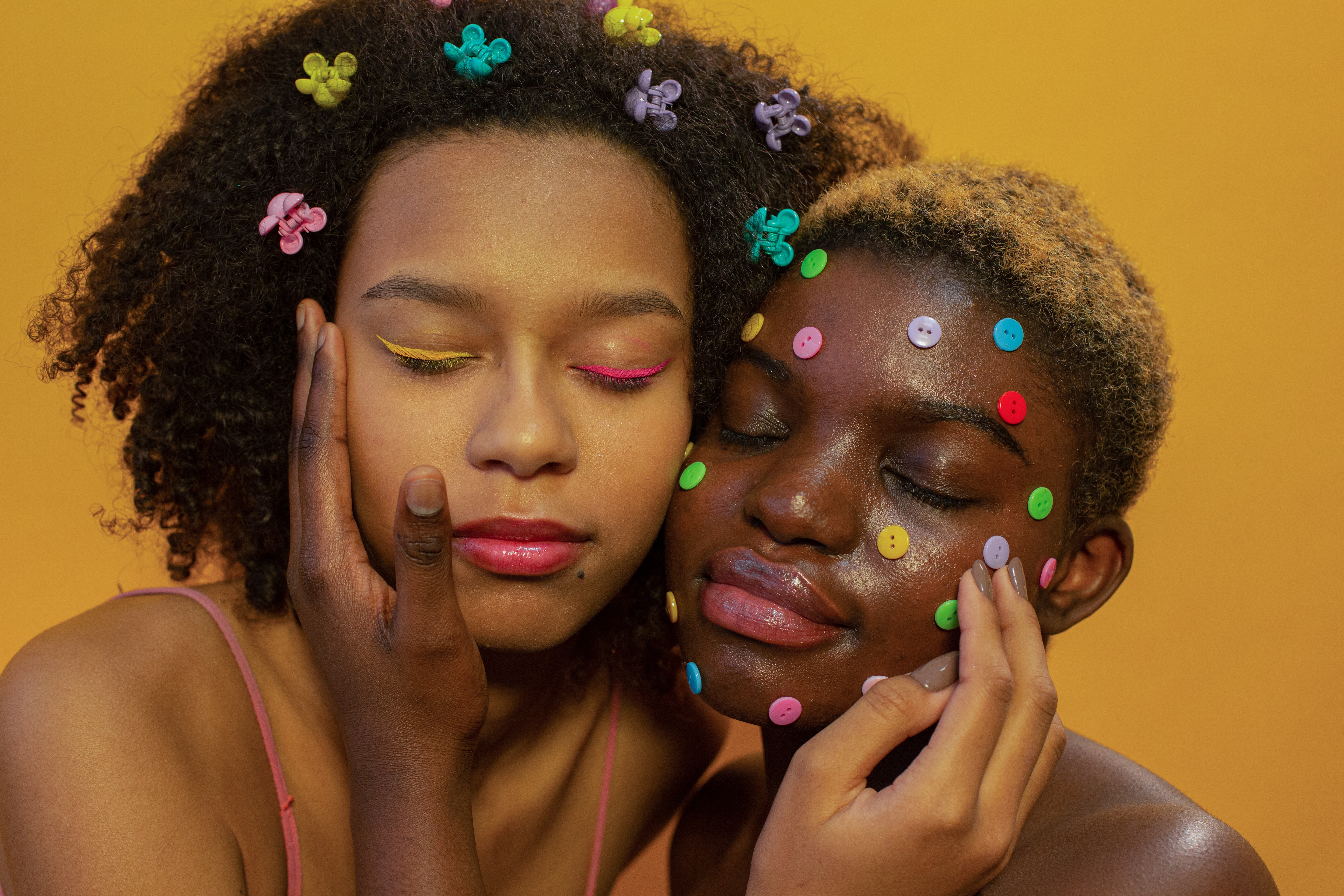 Two ladies wearing colored eyeliners. | Source: Pexels
