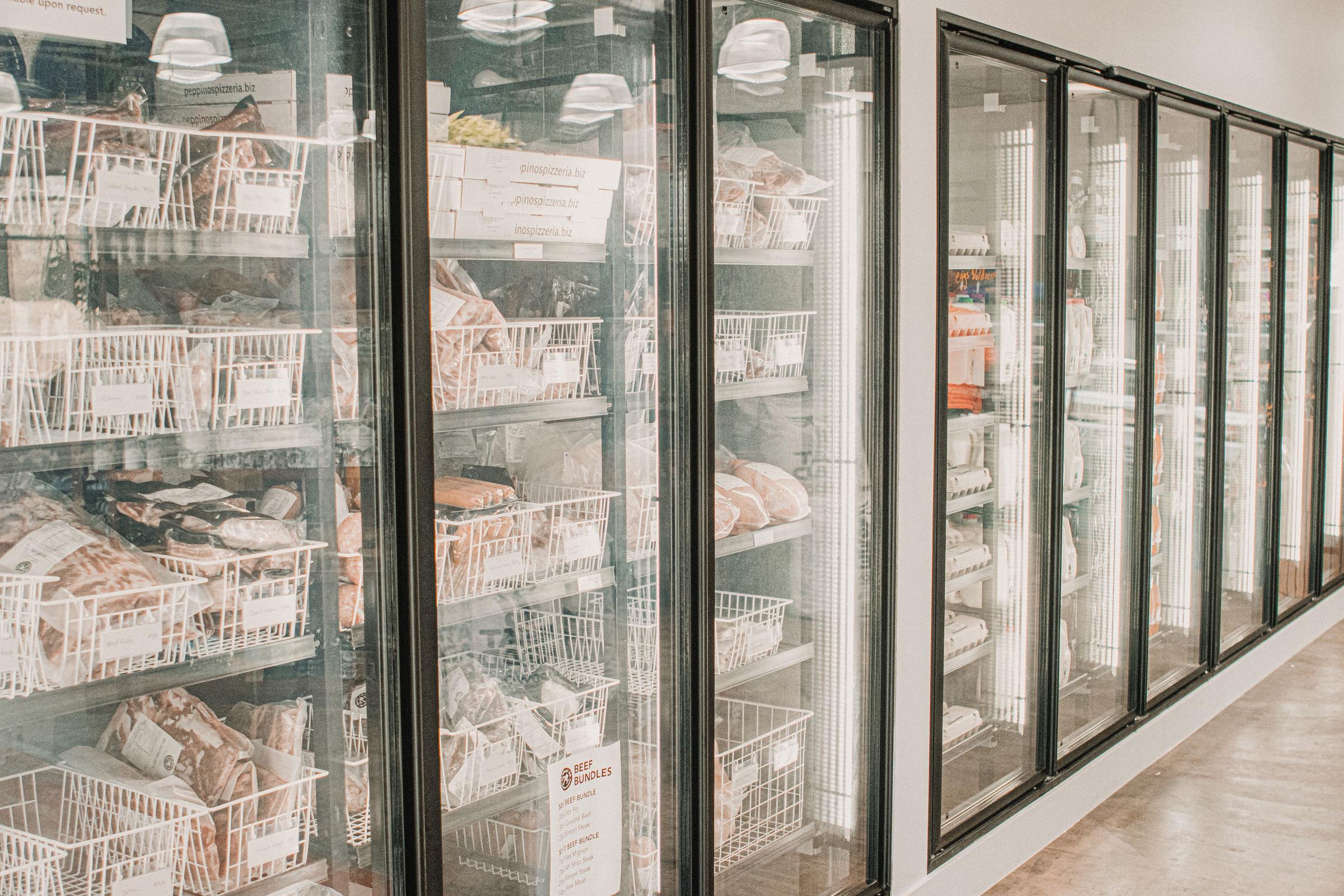 Frozen meats in a retail freezer with transparent doors and organized sections | Source: Pexels