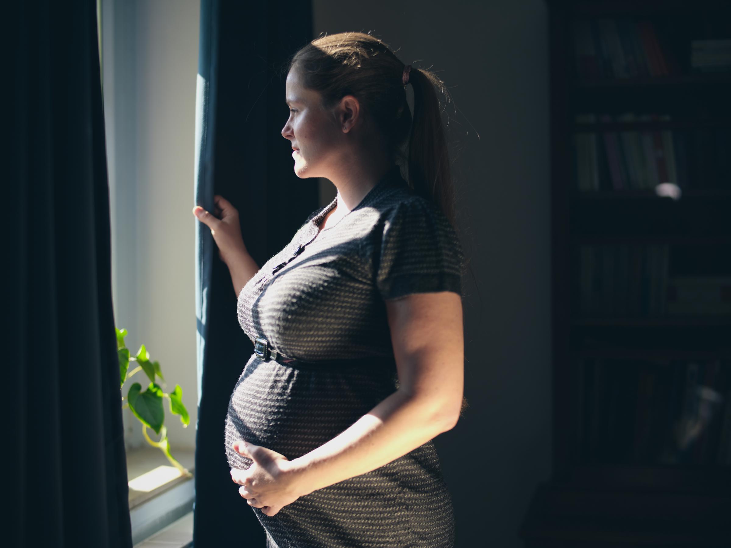 A pregnant woman standing in front of a window | Source: Getty Images