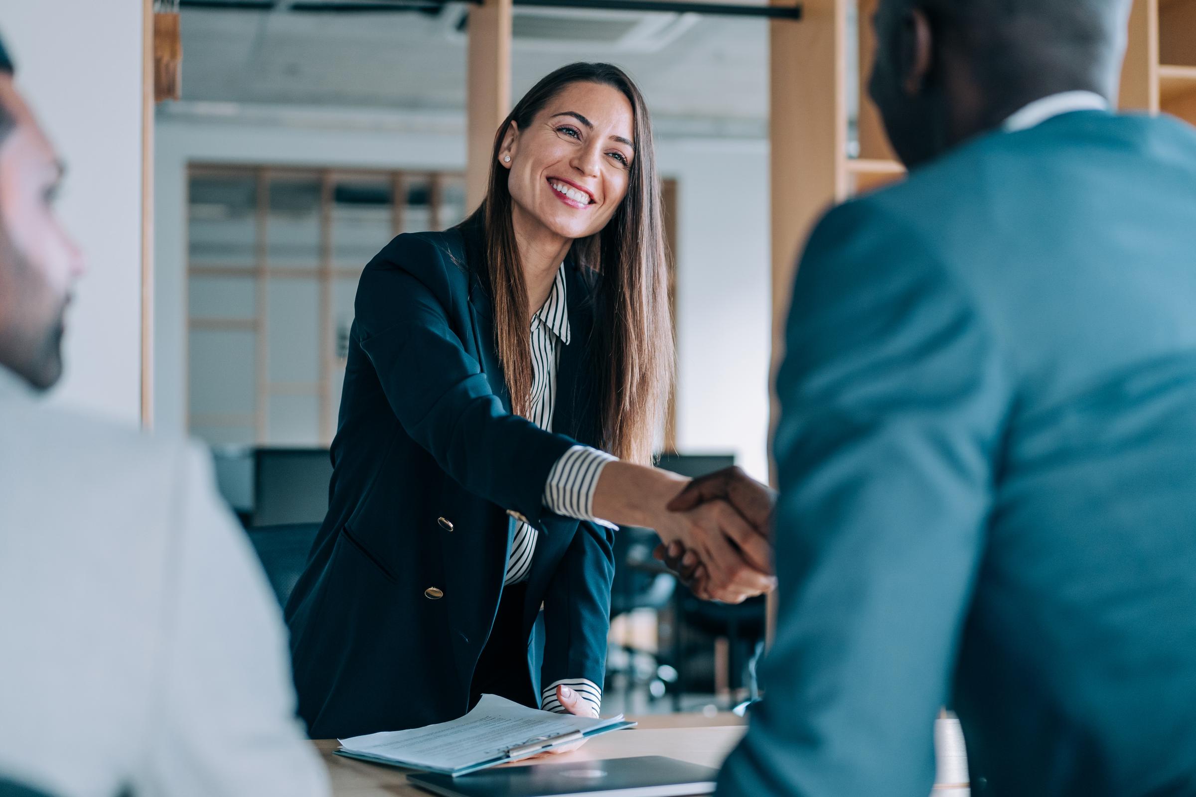 Colleagues shaking hands after a meeting | Source: Getty Images