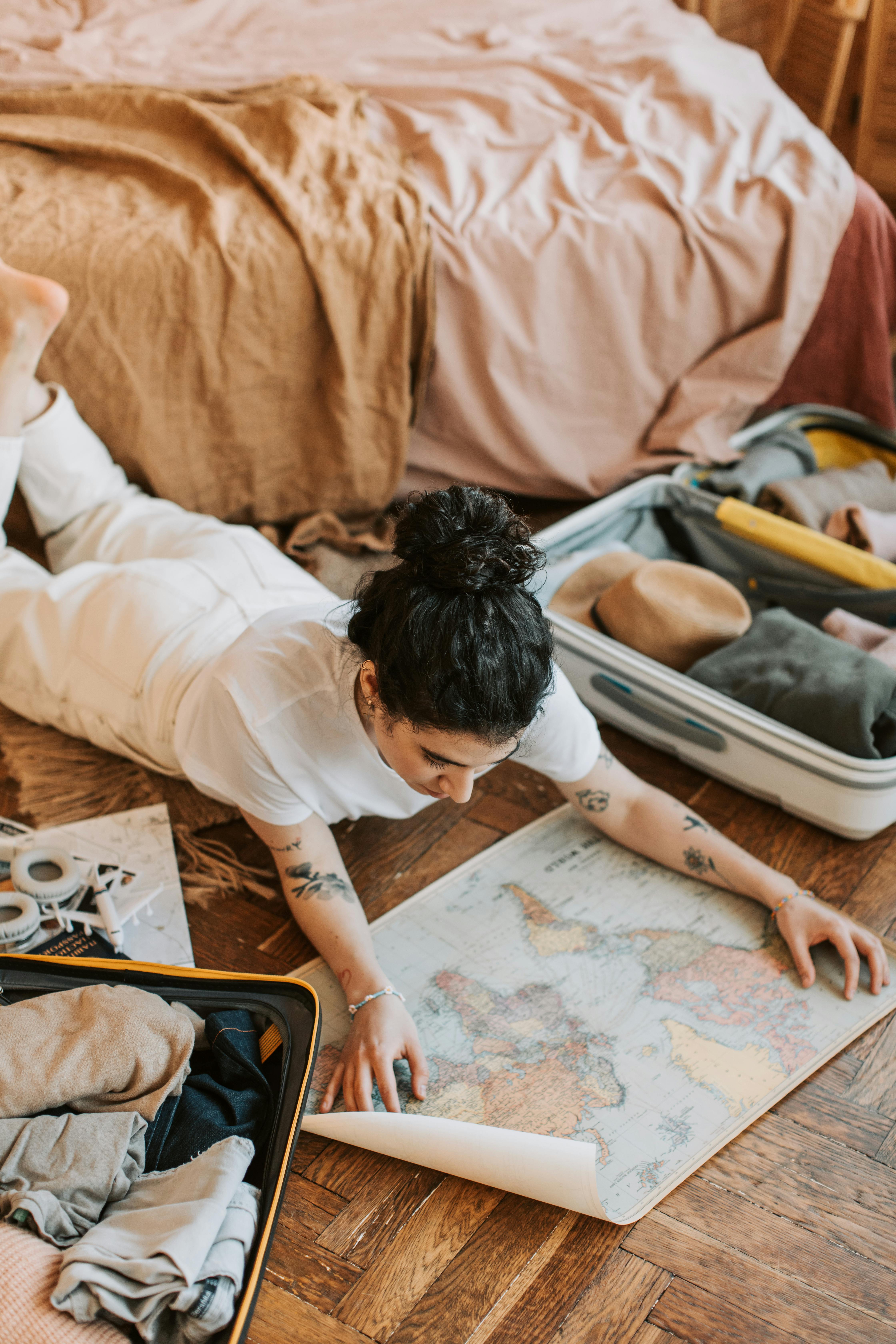 A woman lying on the floor and looking at a map | Source: Pexels