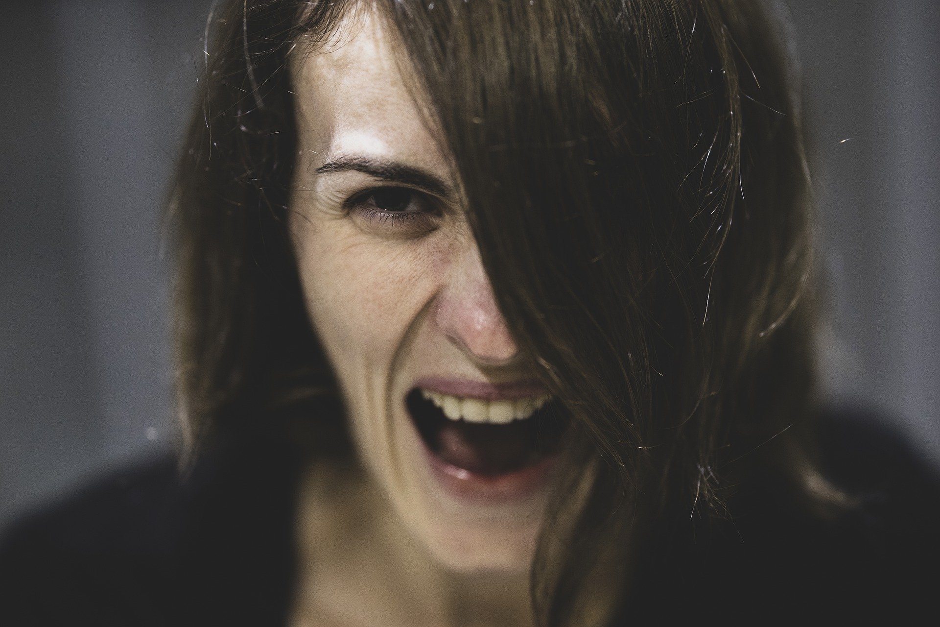 A headshot of a woman shouting with her mouth wide open | Photo: Pixabay/Engin Akyurt