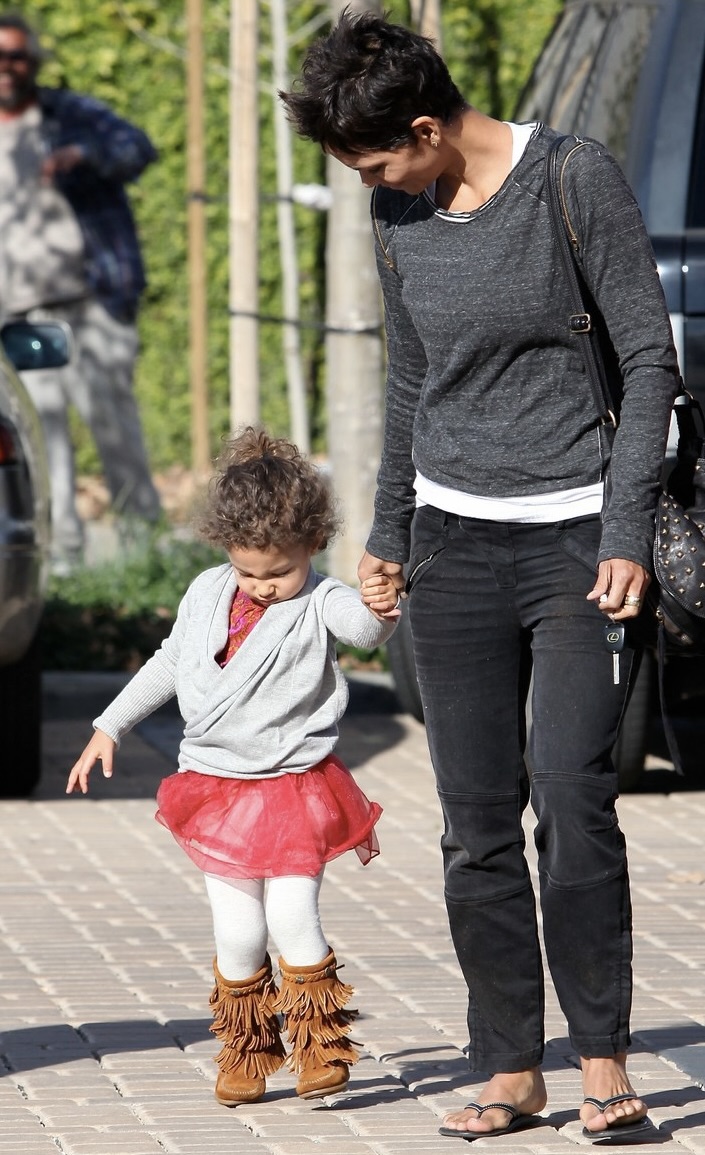Halle Berry held little Nahla's hand during a casual outing, with her daughter wearing a red tutu and fringed boots — a sweet glimpse of her early childhood before the actress began campaigning for stronger paparazzi protections. | Source: Getty Images.