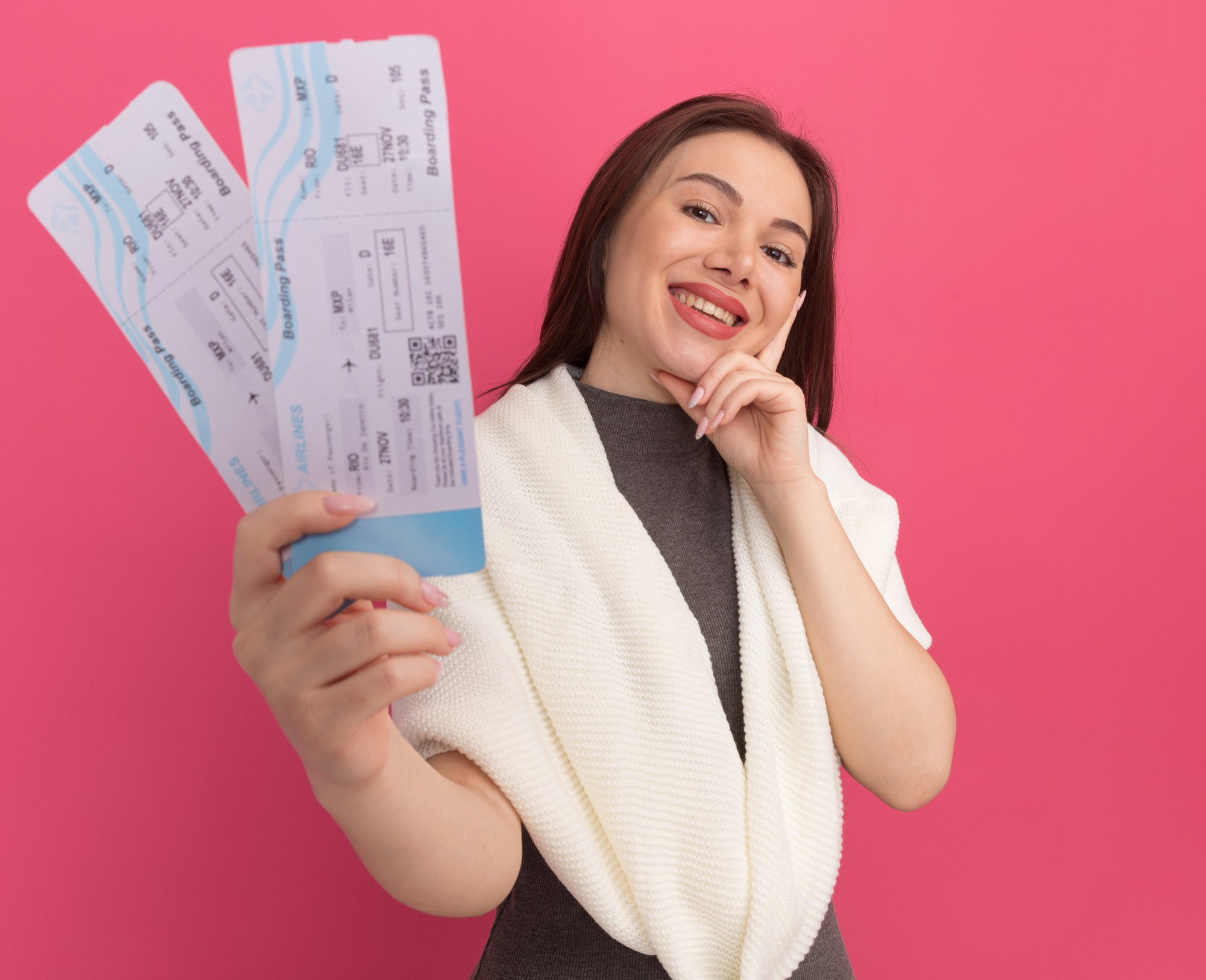 A woman holding two airplane tickets | Source: Freepik